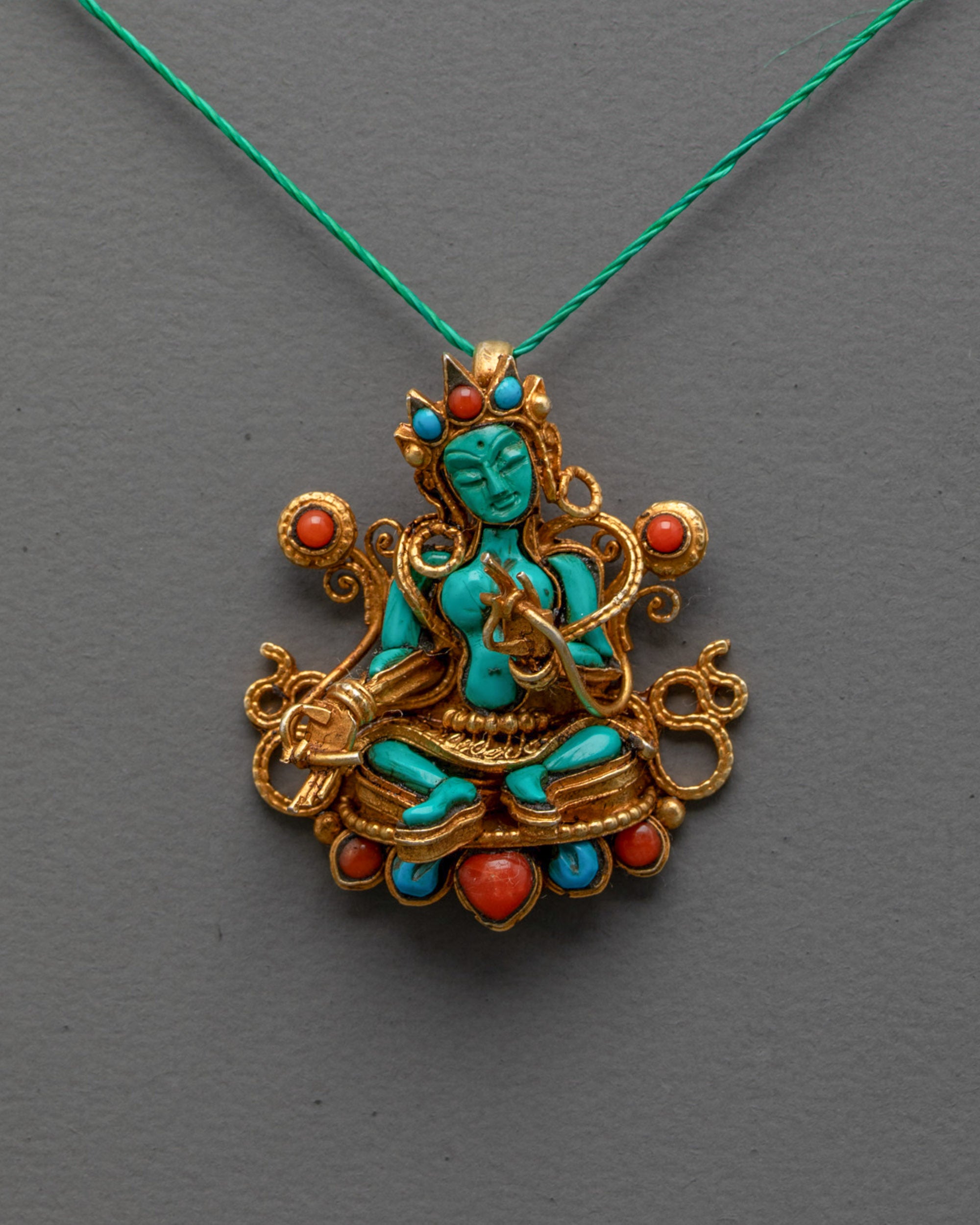 Front view of Authentic Green Tara Locket with turquoise figure and gold-plated filigree
