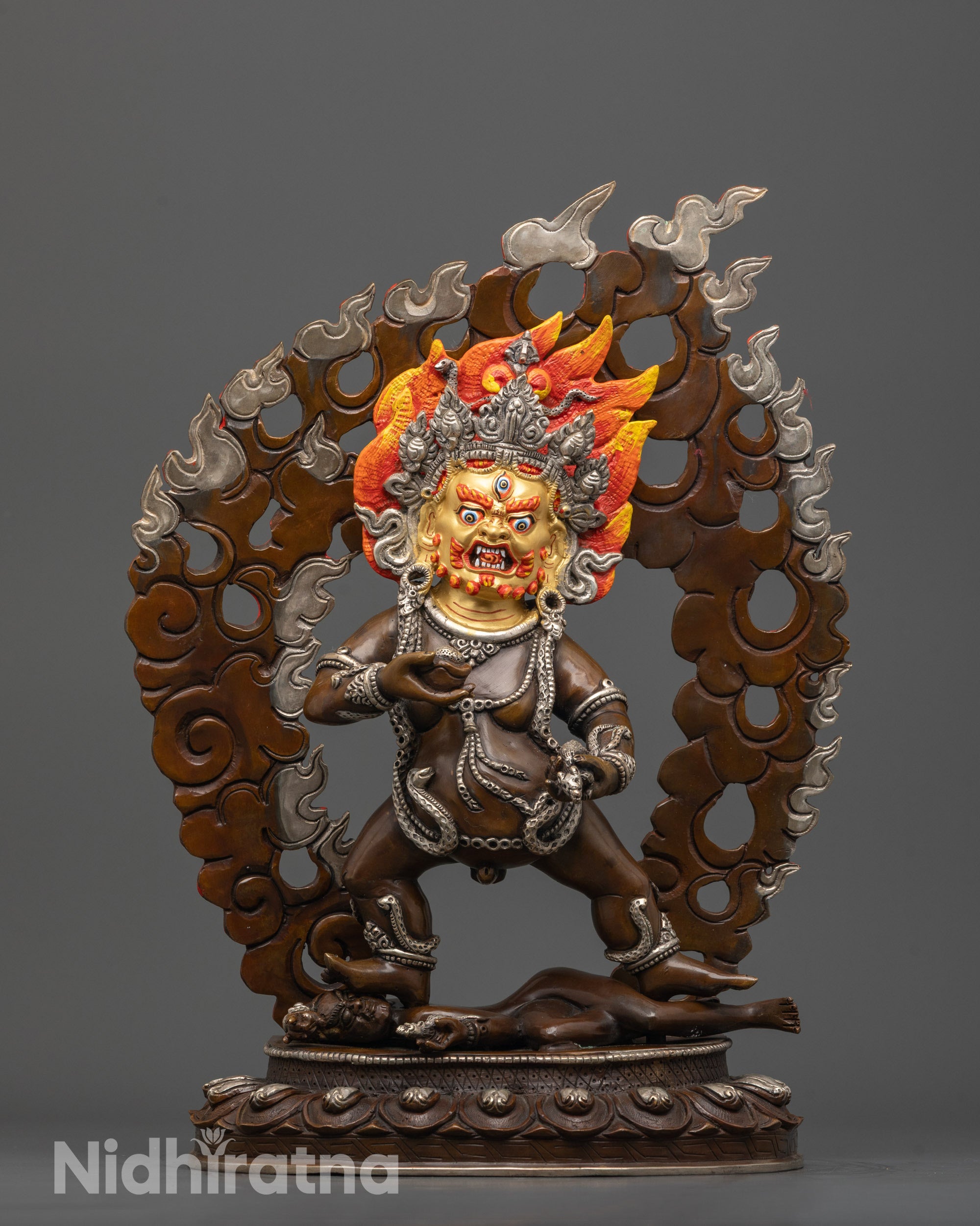 Front view of Black Dzambhala Statue with gold-gilded face and silver-plated crown and halo