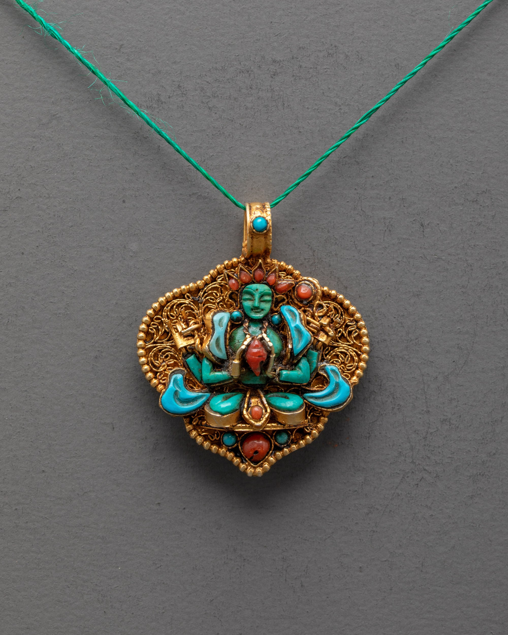 Front view of Chenrezig locket with crystal figure, turquoise robe, and gold-gilded filigree – handcrafted Tibetan Avalokiteshvara amulet.