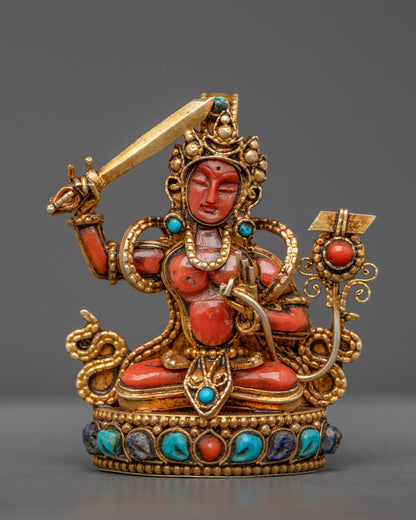 Front view of Coral Manjushri Pendant with gold-gilded sword and detailed filigree design