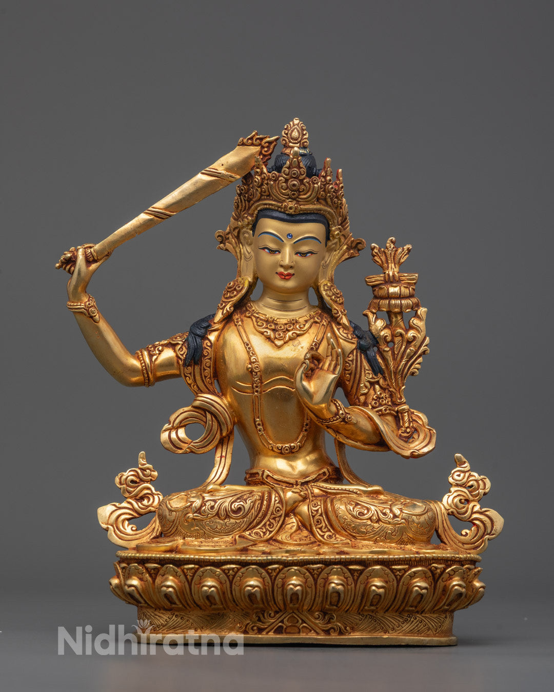 Front view of Divine Manjushri Statue with gold-gilded face and intricate lotus base carvings