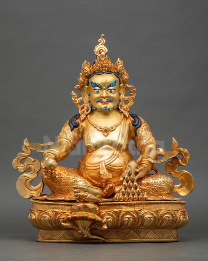 Front view of Dzambhala Statue gold-gilded copper with intricate lotus base details