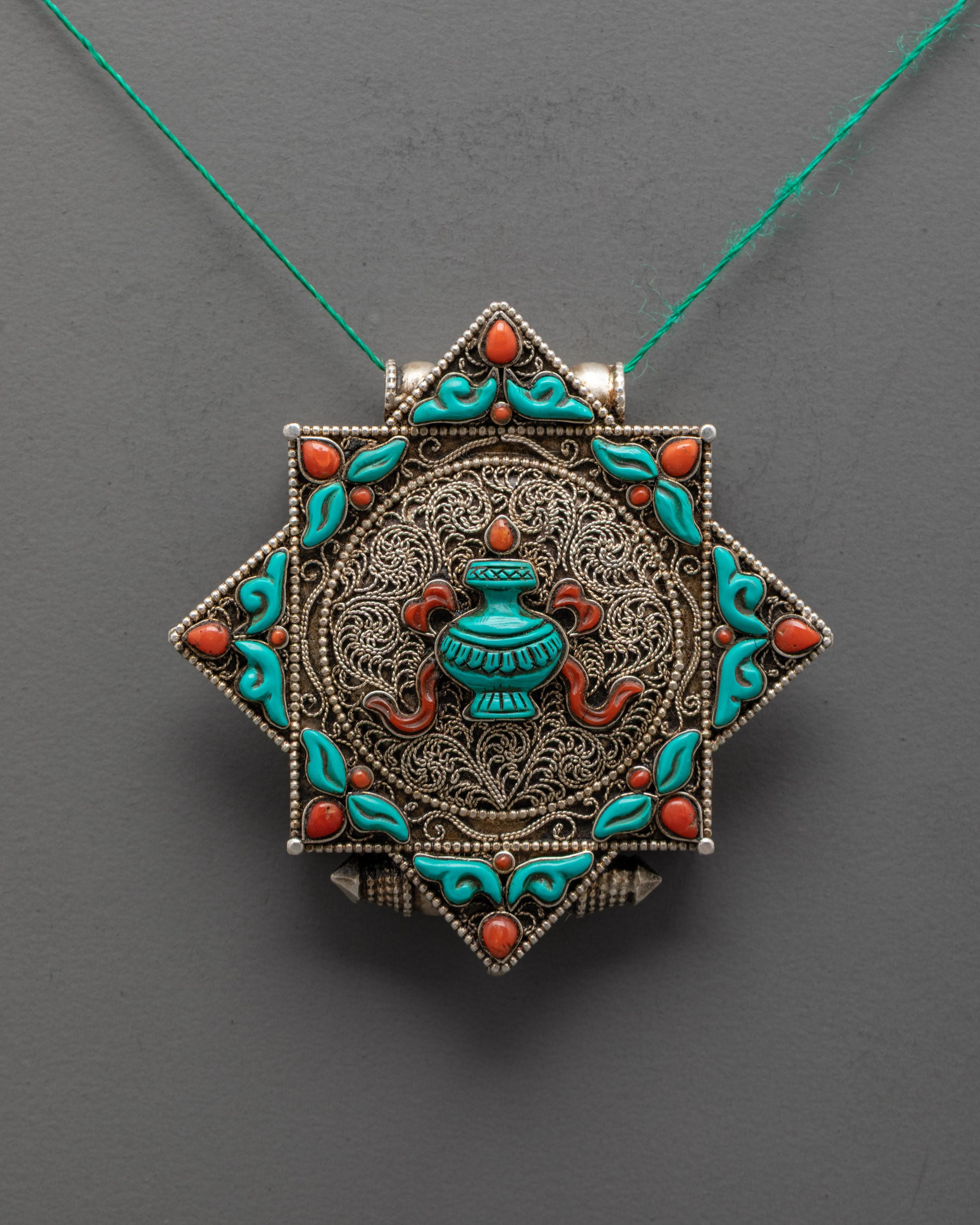 Front view of Exquisite Treasure Vase Locket Necklace with coral, turquoise, and silver filigree design
