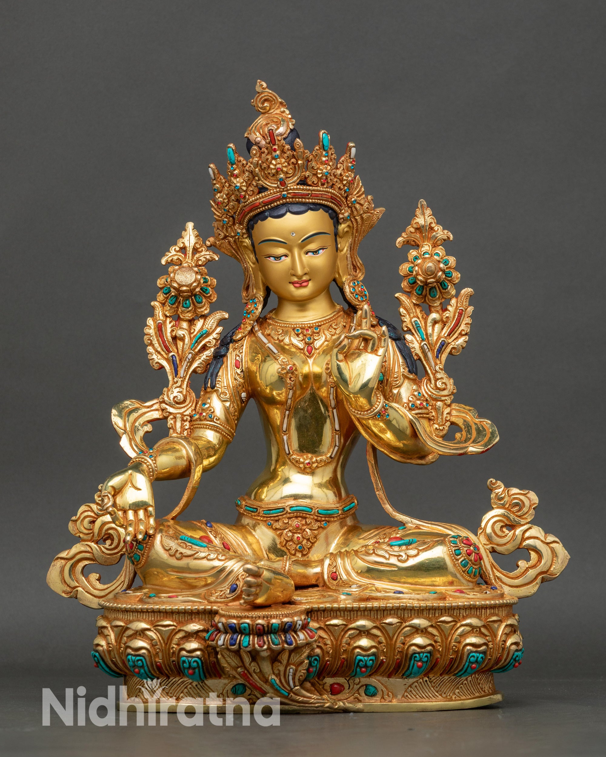 Front view of Green Tara statue seated on lotus throne with gold-painted face