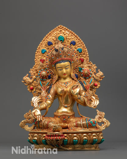 Front view of Green Tara statue with gold-gilded face and utpala flower in hand.