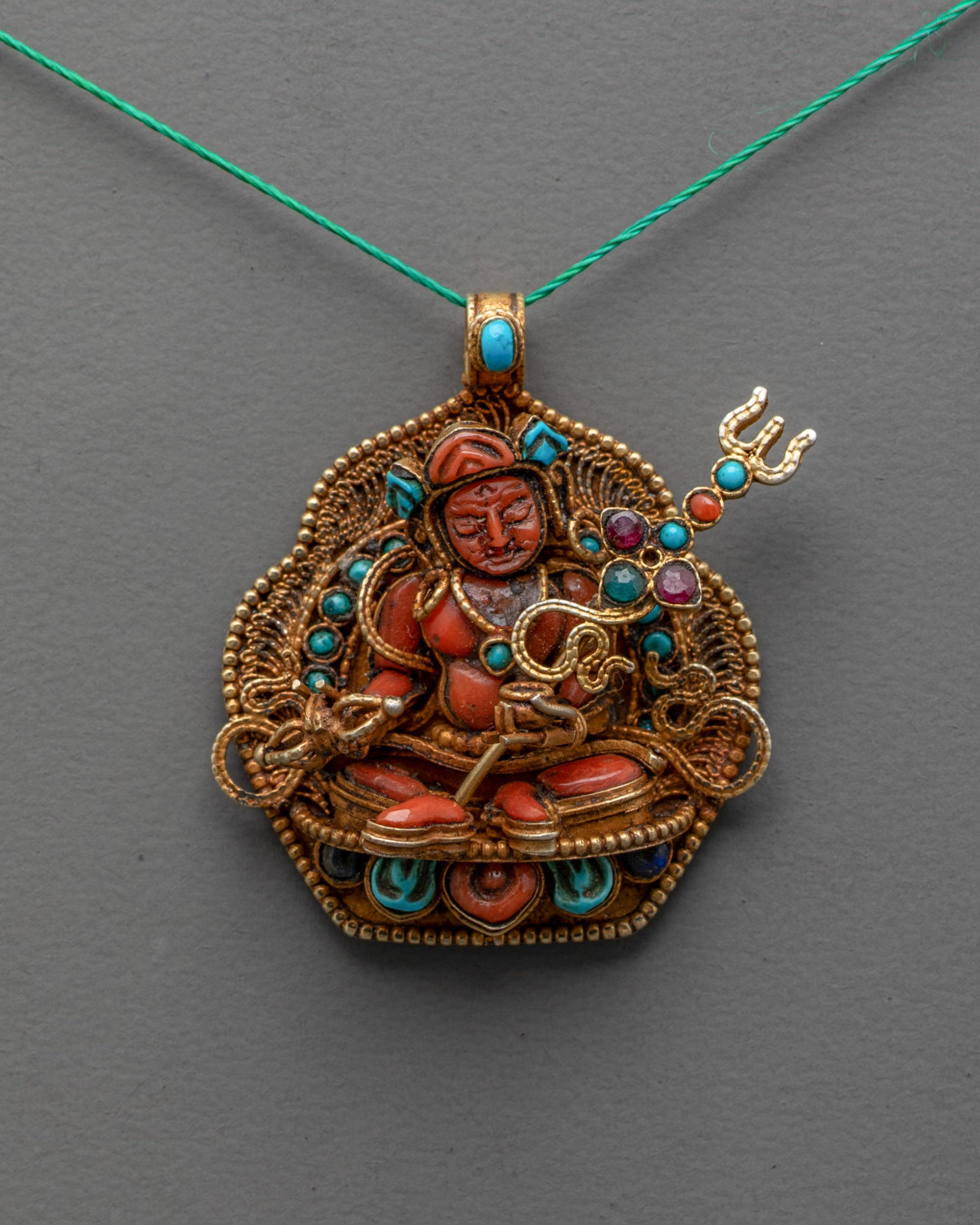 Front view of Guru Padmasambhava Locket with coral figure and gold-plated filigree design