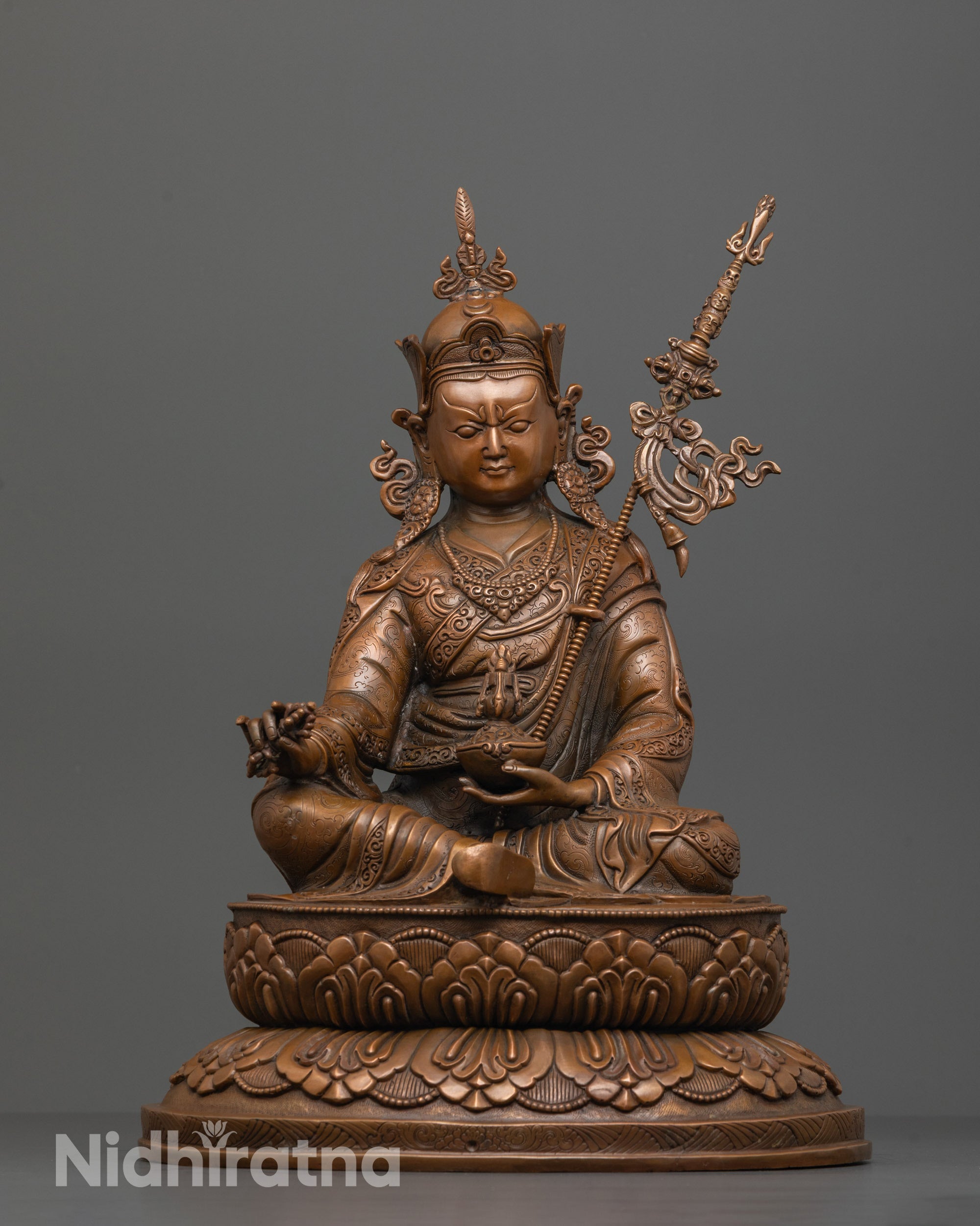 Front view of Guru Padmasambhava statue with kapala trident and vajra on lotus seat