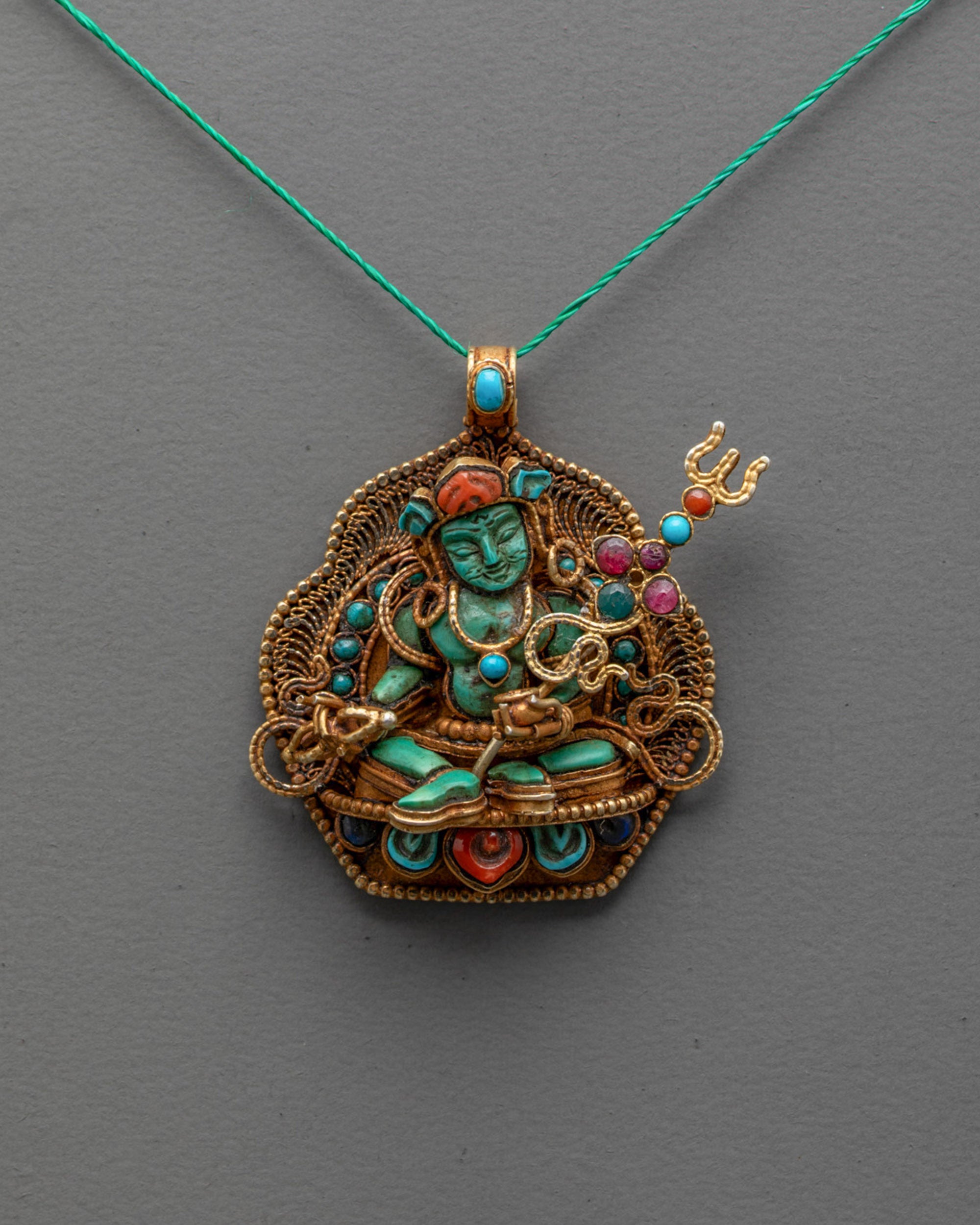 Front view of Guru Rinpoche Pendant with turquoise body and coral lotus crown