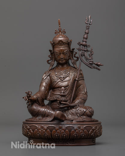 Front view of Guru Rinpoche statue seated on lotus base with vajra and skull cup
