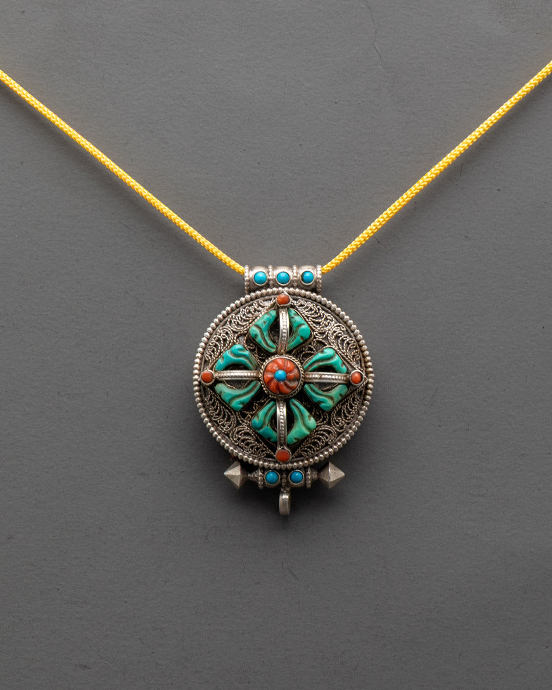 Front view of Handcrafted Bishwo Vajra Locket with filigree design and turquoise stones