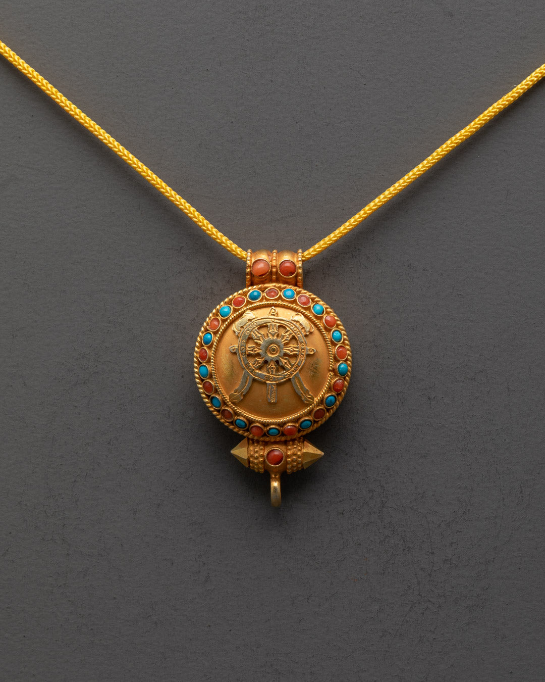 Front view of Khorlo Wheel of Wisdom Locket with gold-gilded Dharma Wheel design