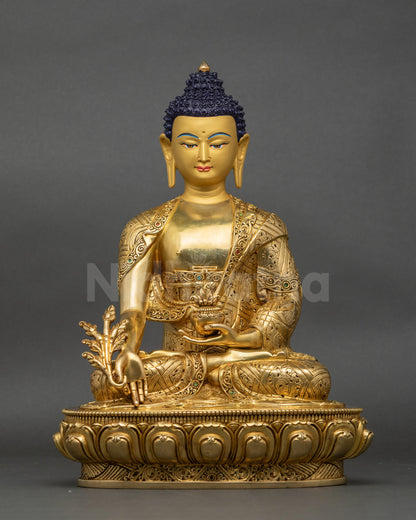Front view of Medicine Buddha statue on lotus seat with kasaya robe and gold face