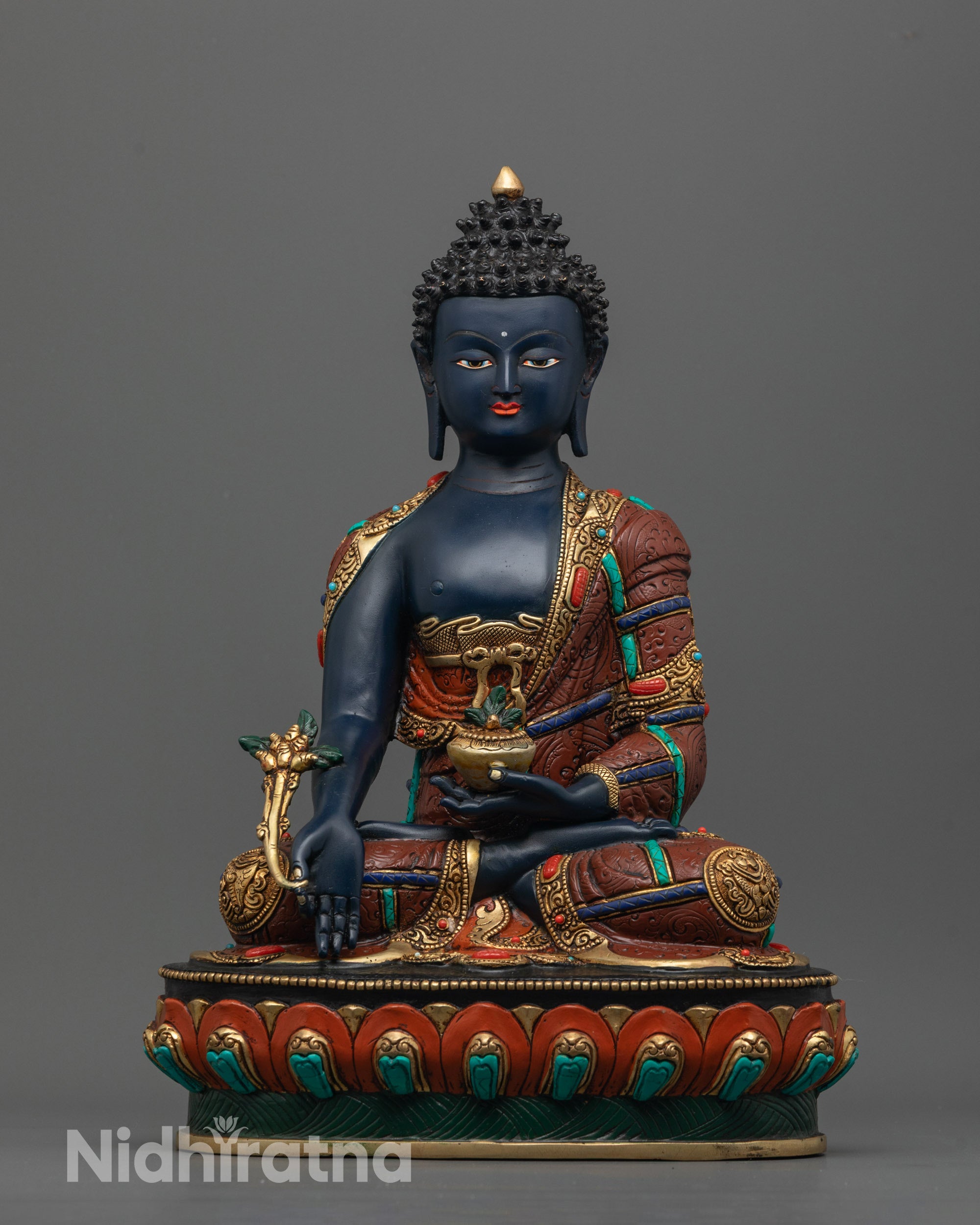 Front view of Medicine Buddha statue with gold-gilded face and lotus base
