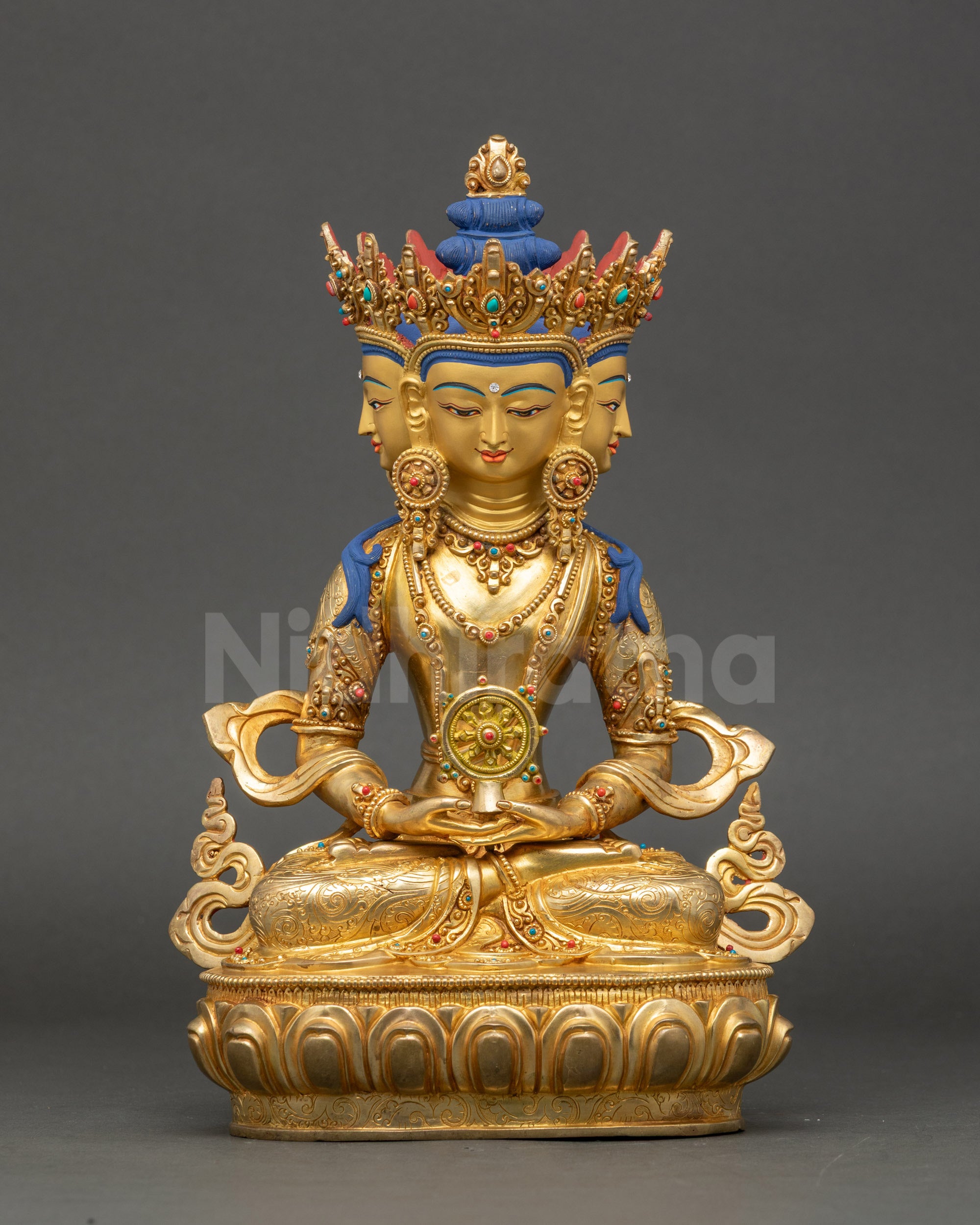 Front view of Nepalese Vairocana Buddha statue with four gold-gilded faces and lotus base