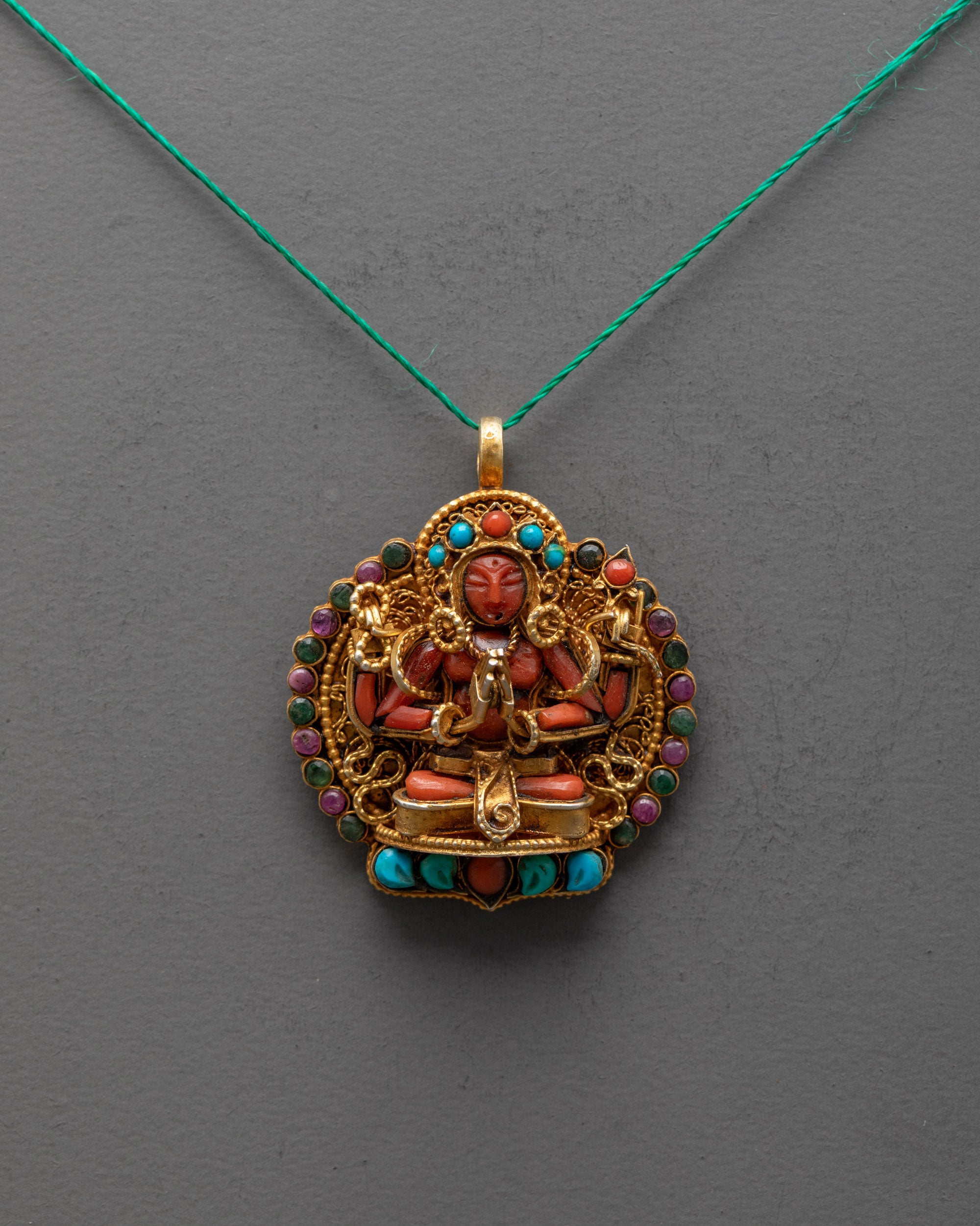Front view of Red Crystal Chenrezig Locket with gold-gilded filigree and semi-precious stones, handcrafted by artisans from Patan, Nepal.