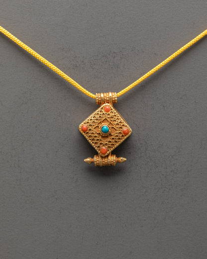 Front view of Religious Tibetan Pendant with gold gilding and vibrant semi-precious stones
