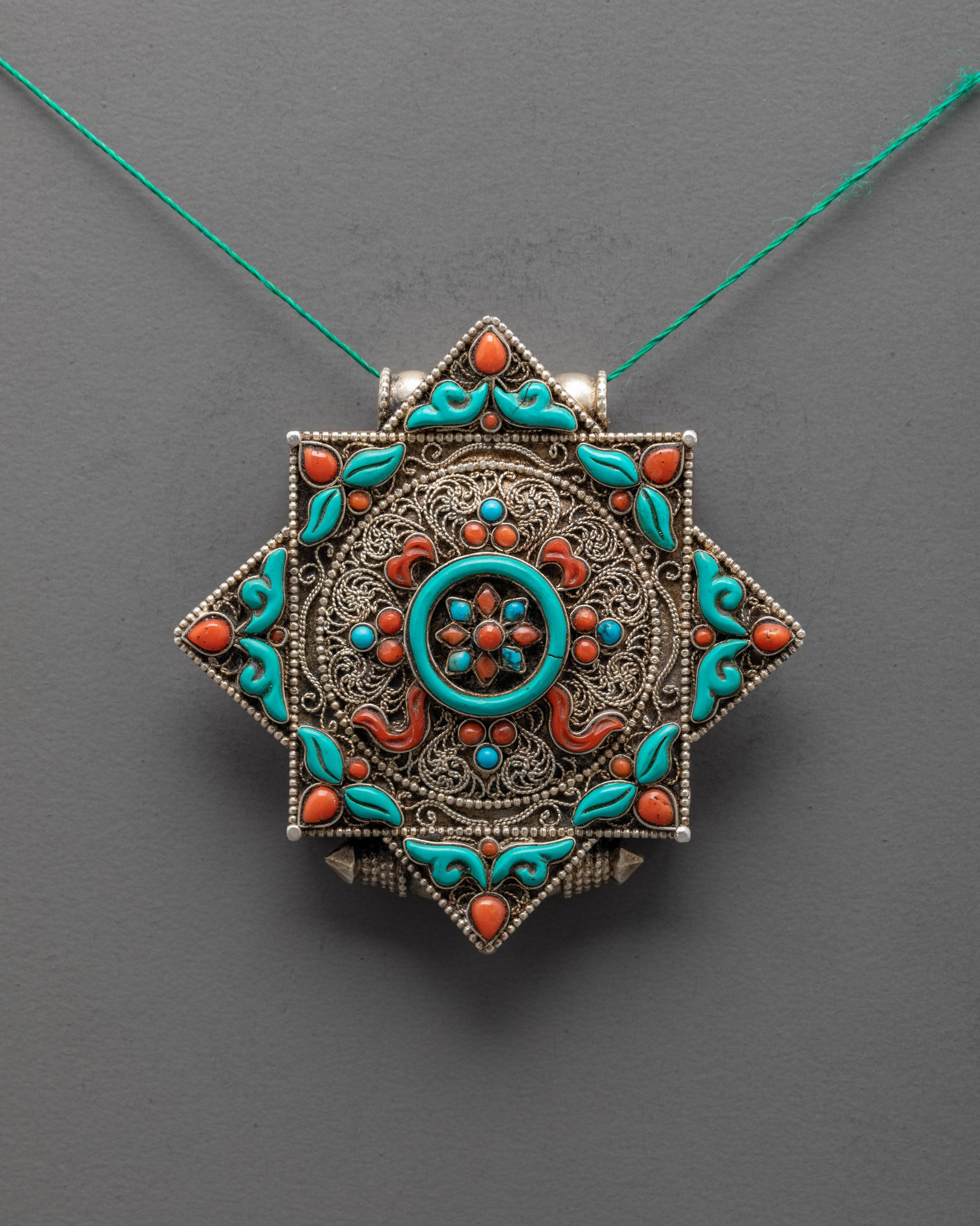 Front view of Sacred Dharma Wheel Locket with turquoise center and silver filigree