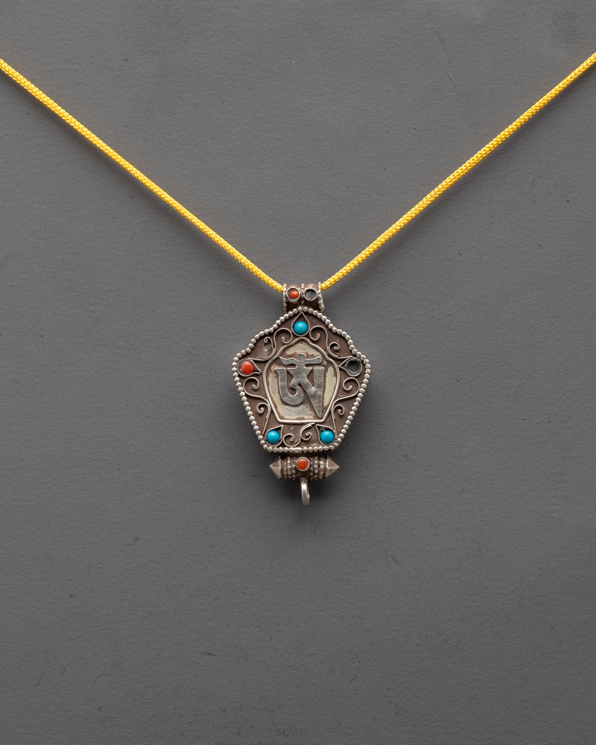 Front view of Sacred Om Pendant with silver-plated Om and filigree copper body