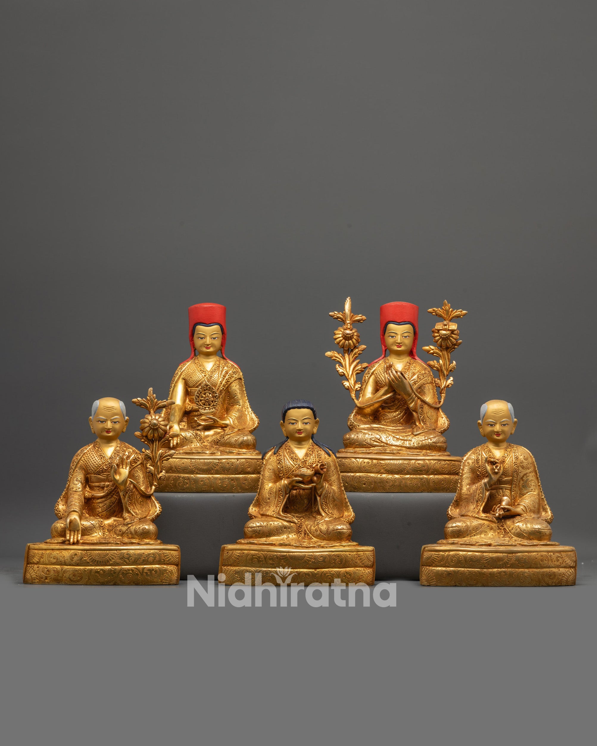 Front view of Sakya Master Set Statue with gold-gilded faces and copper base