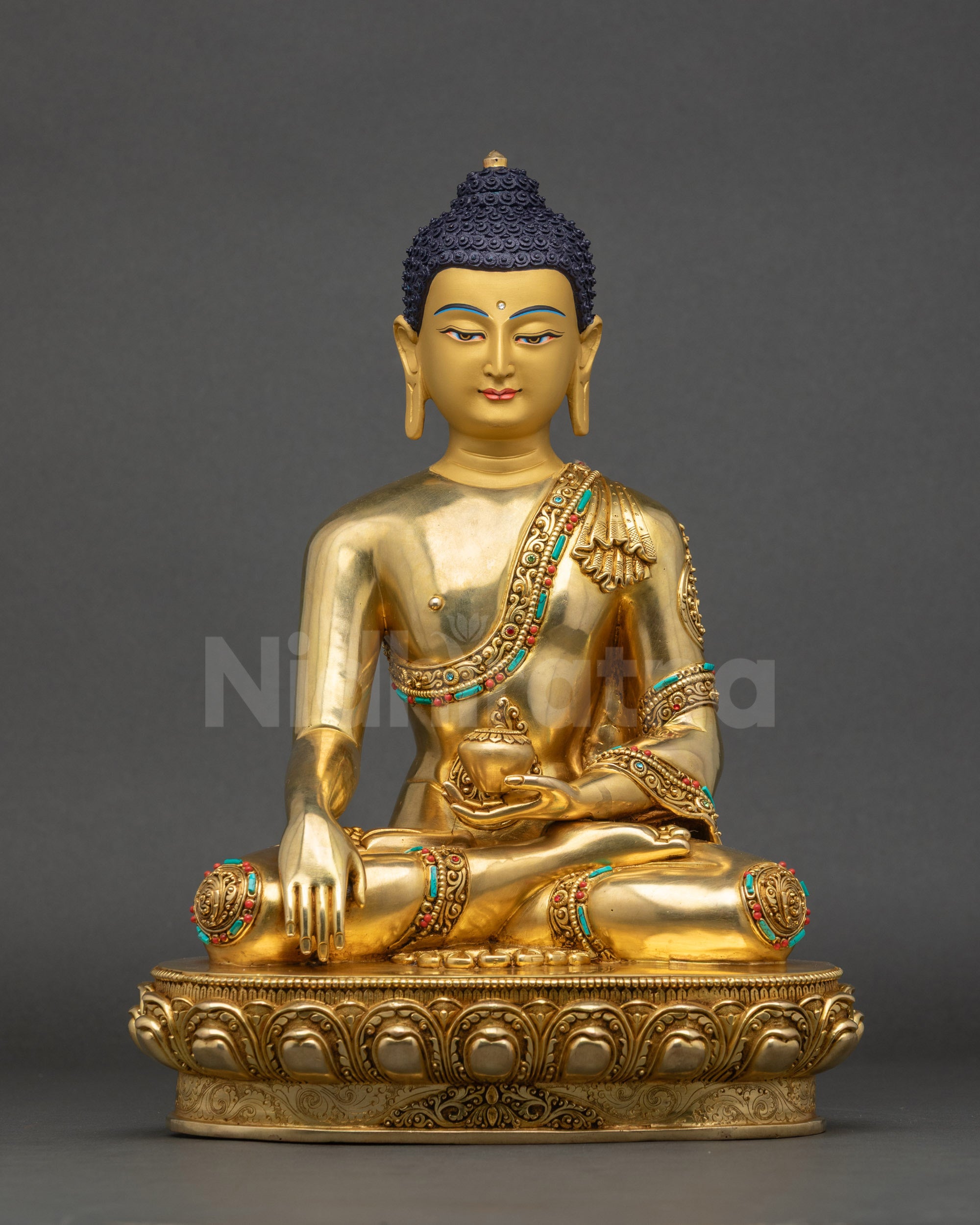 Peaceful Shakyamuni Buddha statue seated on lotus with gold face and begging bowla
