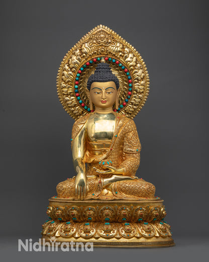 Front view of Shakyamuni Buddha statue gold-gilded with lotus pedestal and halo