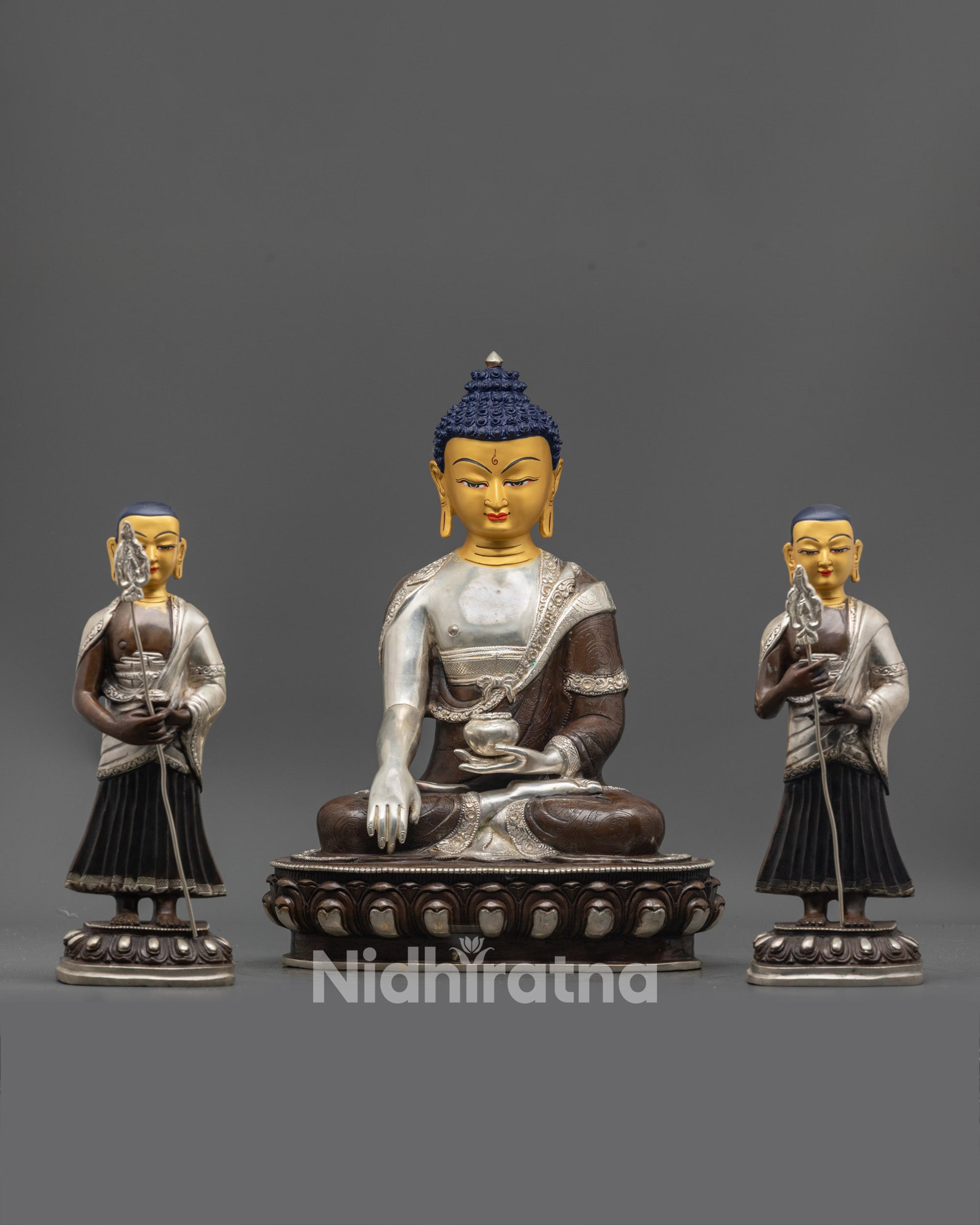 Front view of Shakyamuni Buddha with Disciples statue showing gold-gilded face and lotus seats