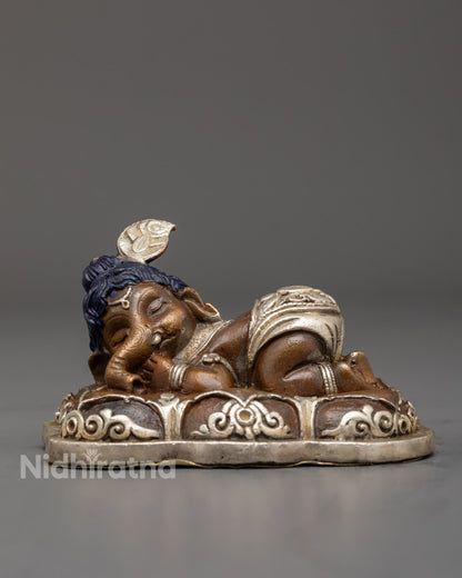Sleeping Bal Ganesha Statue in oxidized copper with silver plating and vibrant acrylic colors – handcrafted in Nepal
