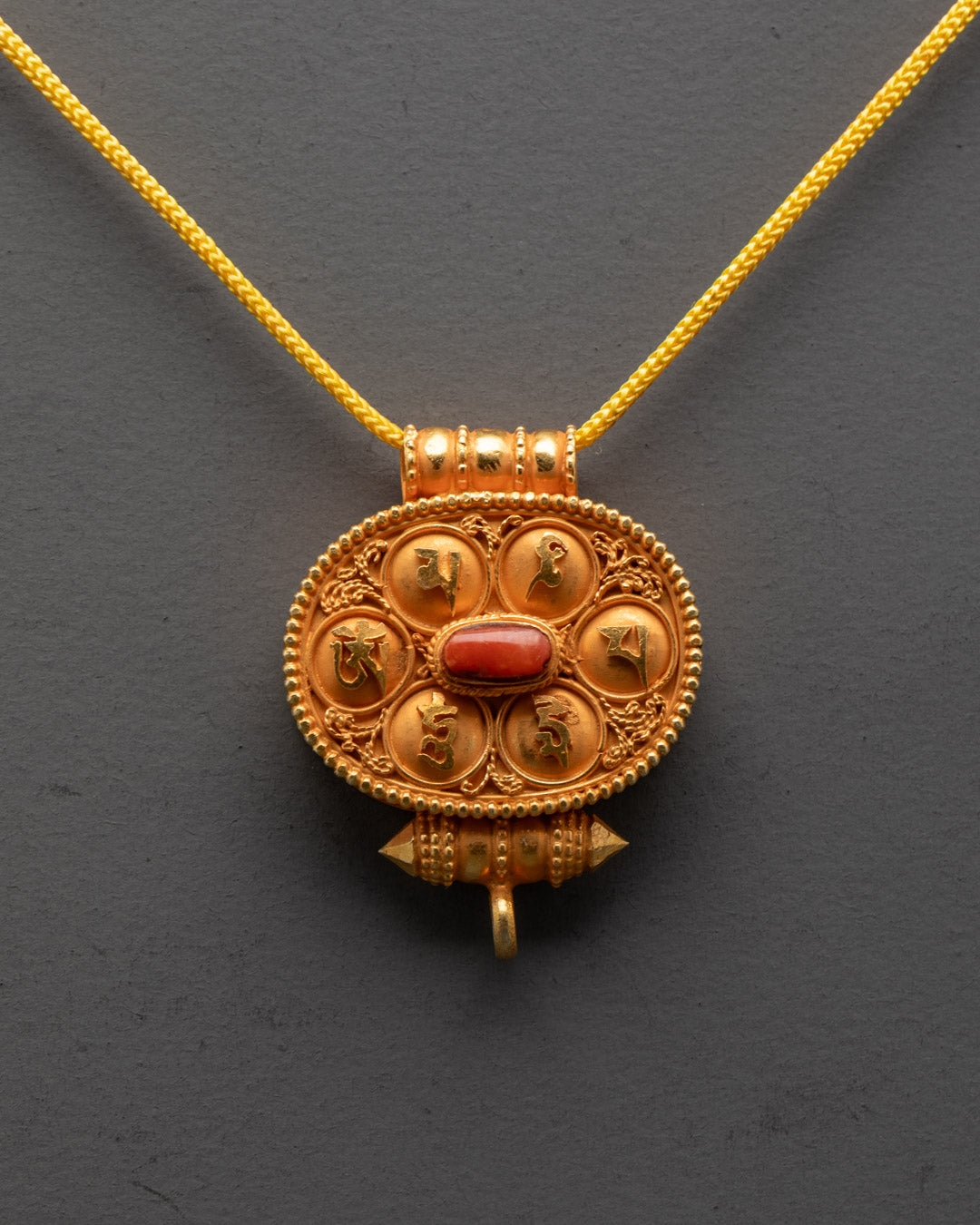 Front view of Tibetan Ghau Prayer Box with gold filigree and coral stones
