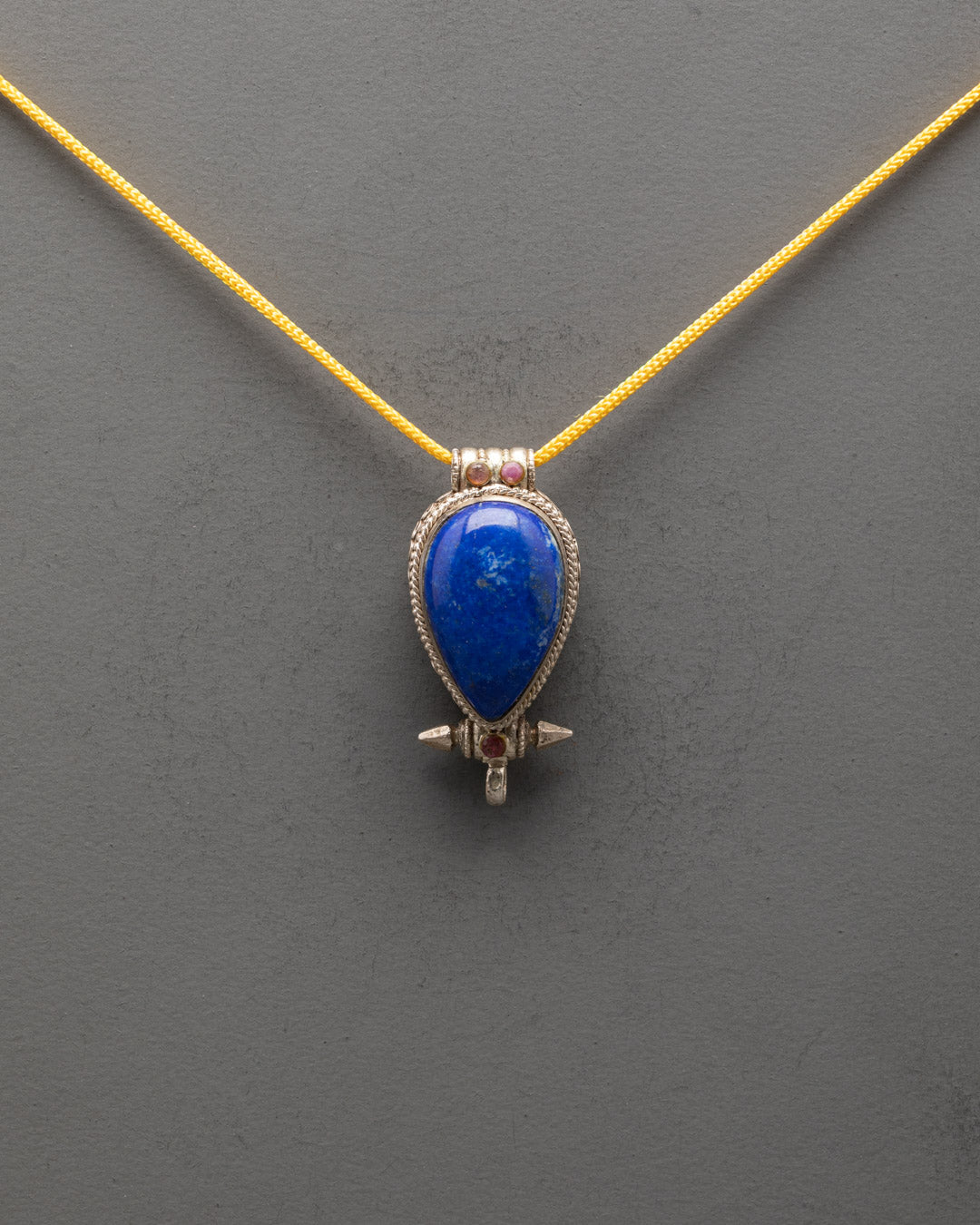 Front view of Tibetan Lapis Lazuli locket with coral accents and intricate silver design

