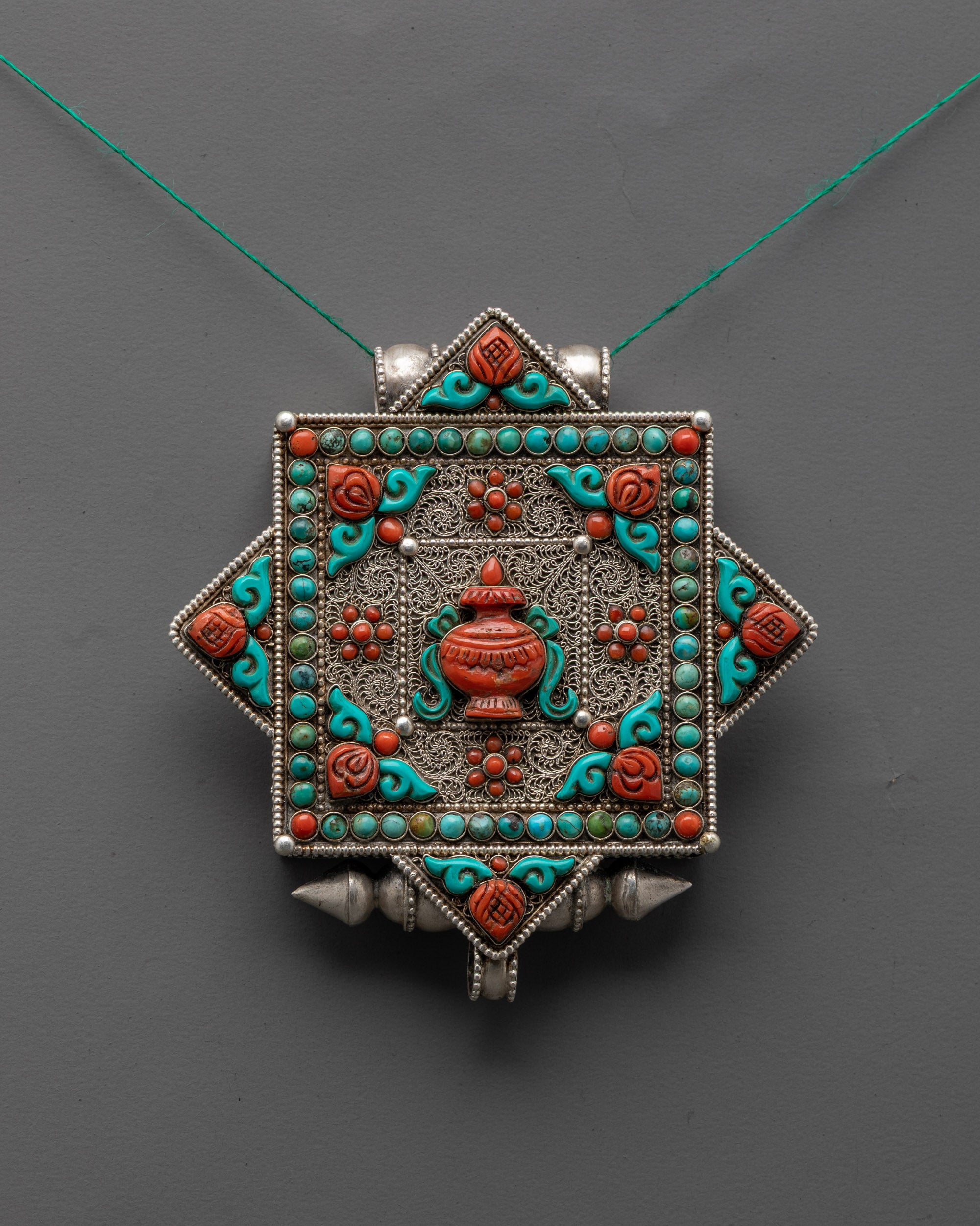Front view of Tibetan Treasure Vase Locket with silver body and coral turquoise stones close up