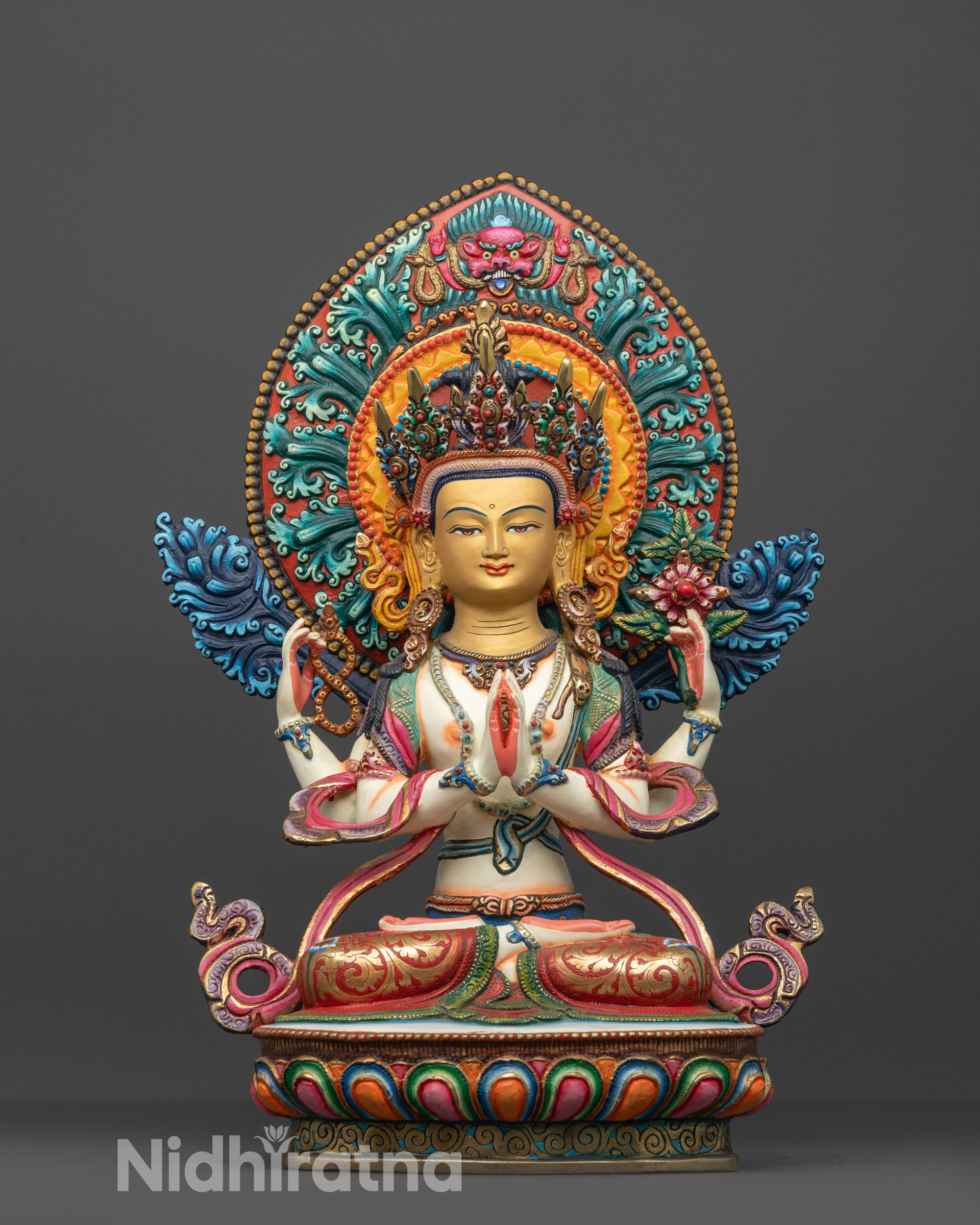 Front view of a hand painted Chenrezig statue from Nepal with a gold gilded face.
