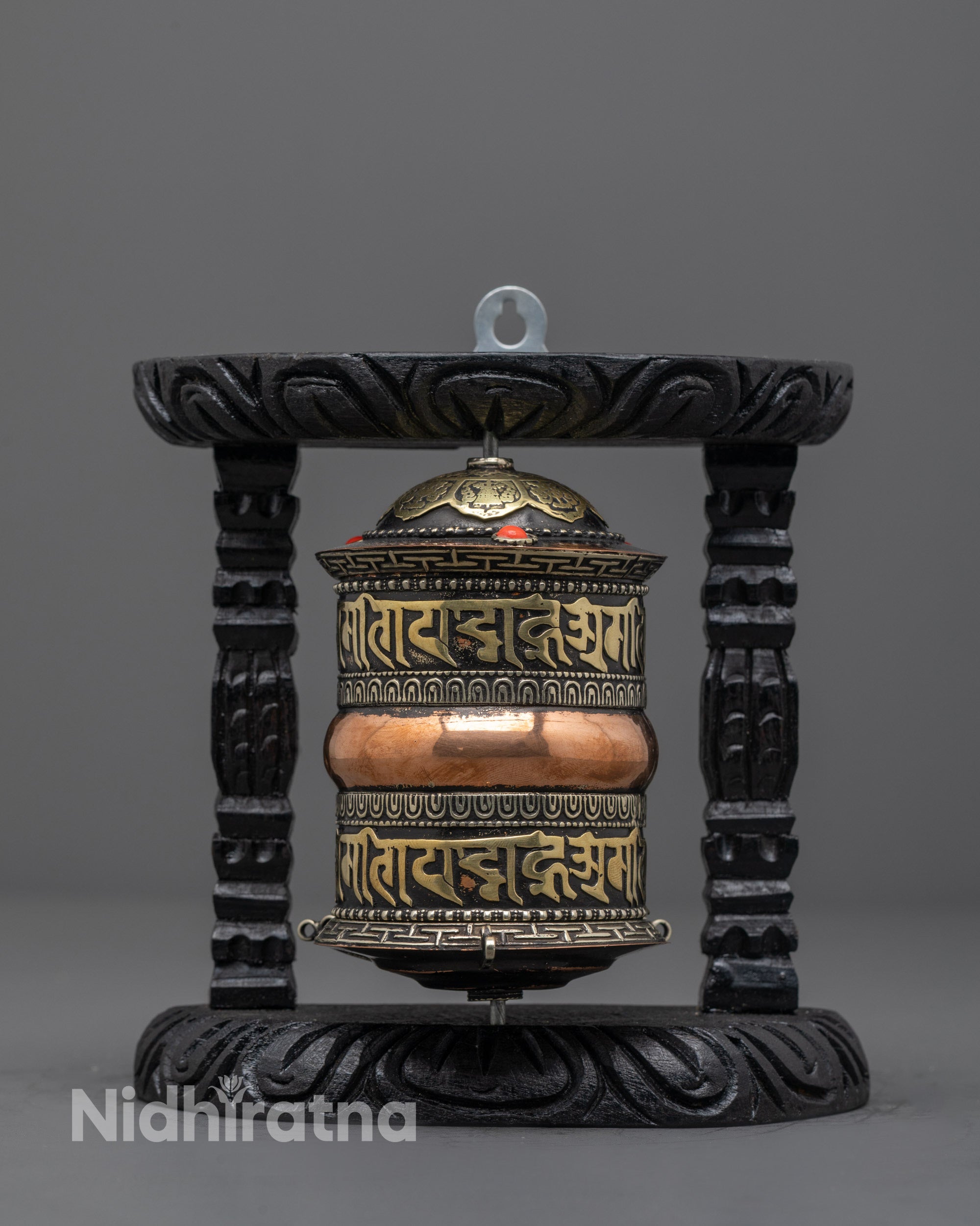 Front view of artisan-made copper Tibetan prayer wheel with brass and coral details