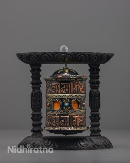 Front view of copper and brass mantra prayer wheel with turquoise and coral stones
