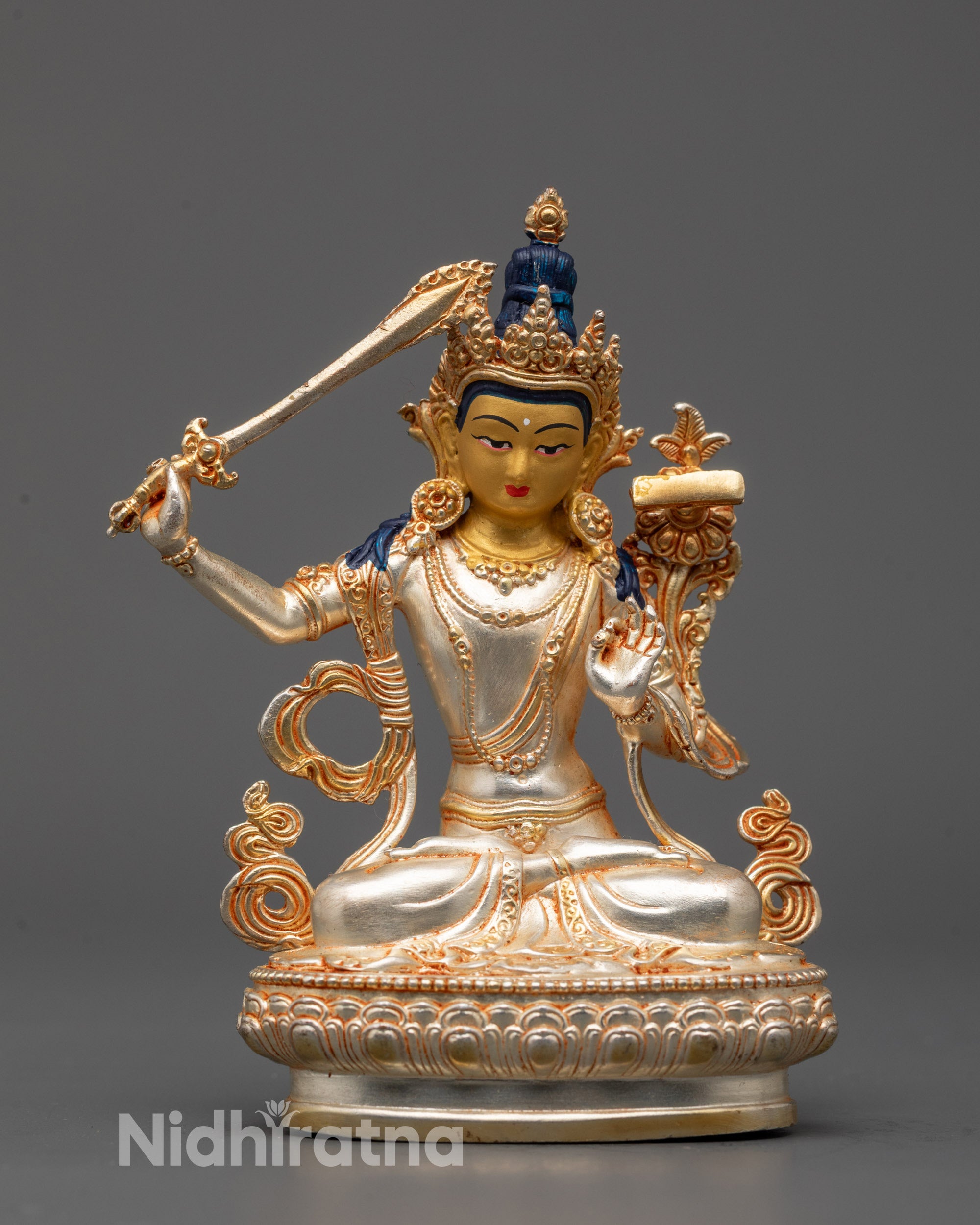 Front view of electroplated Manjushri statue with gold face and silver body
