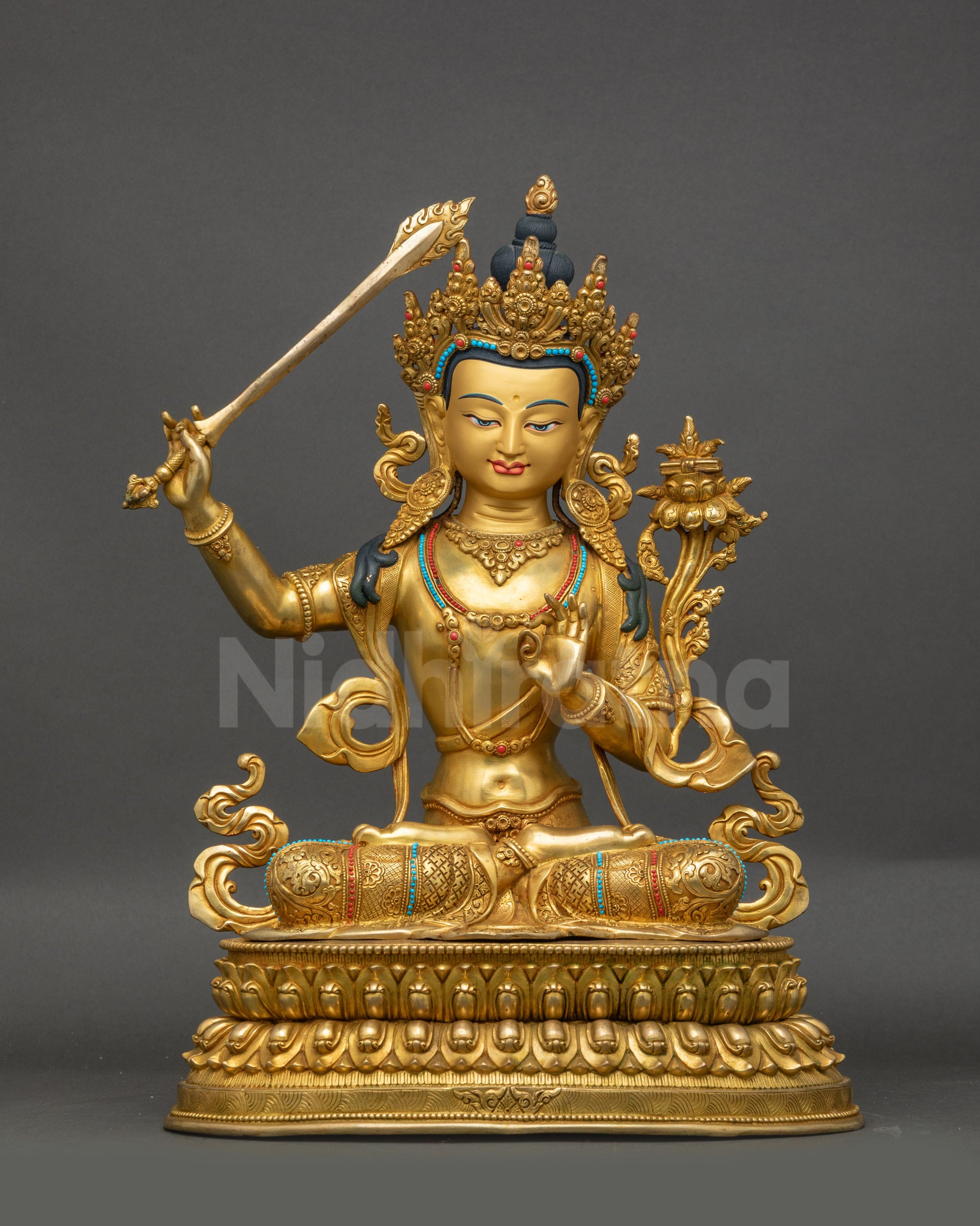 Front view of gold-gilded Bodhisattva Manjushri statue on lotus meditation posture