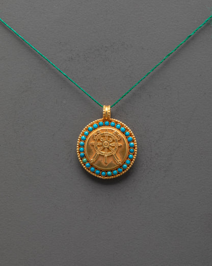 Front view of gold-plated Dharma Wheel Locket with filigree and semi-precious stones
