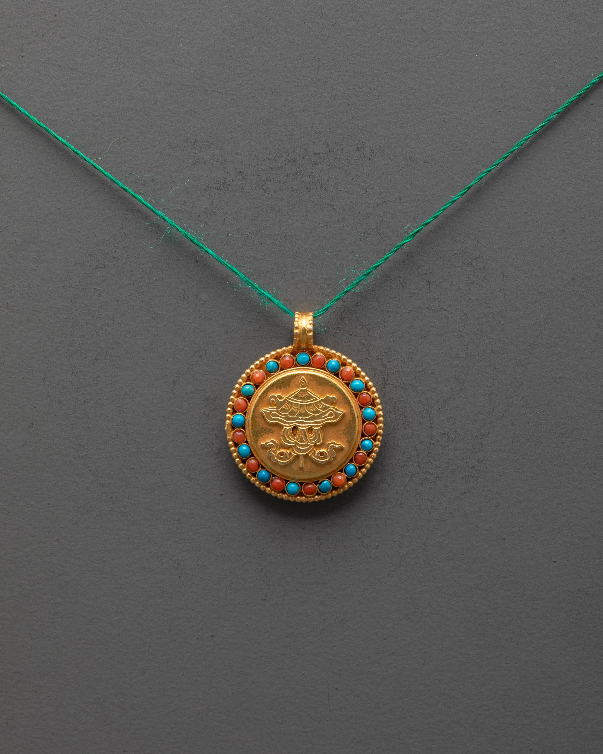 Front view of gold-plated Victory Banner Pendant with semi-precious stones, handcrafted in Nepal