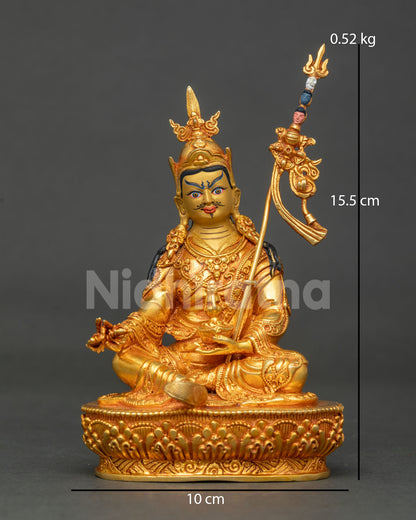 Front view of gold fire-gilded copper Guru Rinpoche statue with khatvanga staff and lotus base