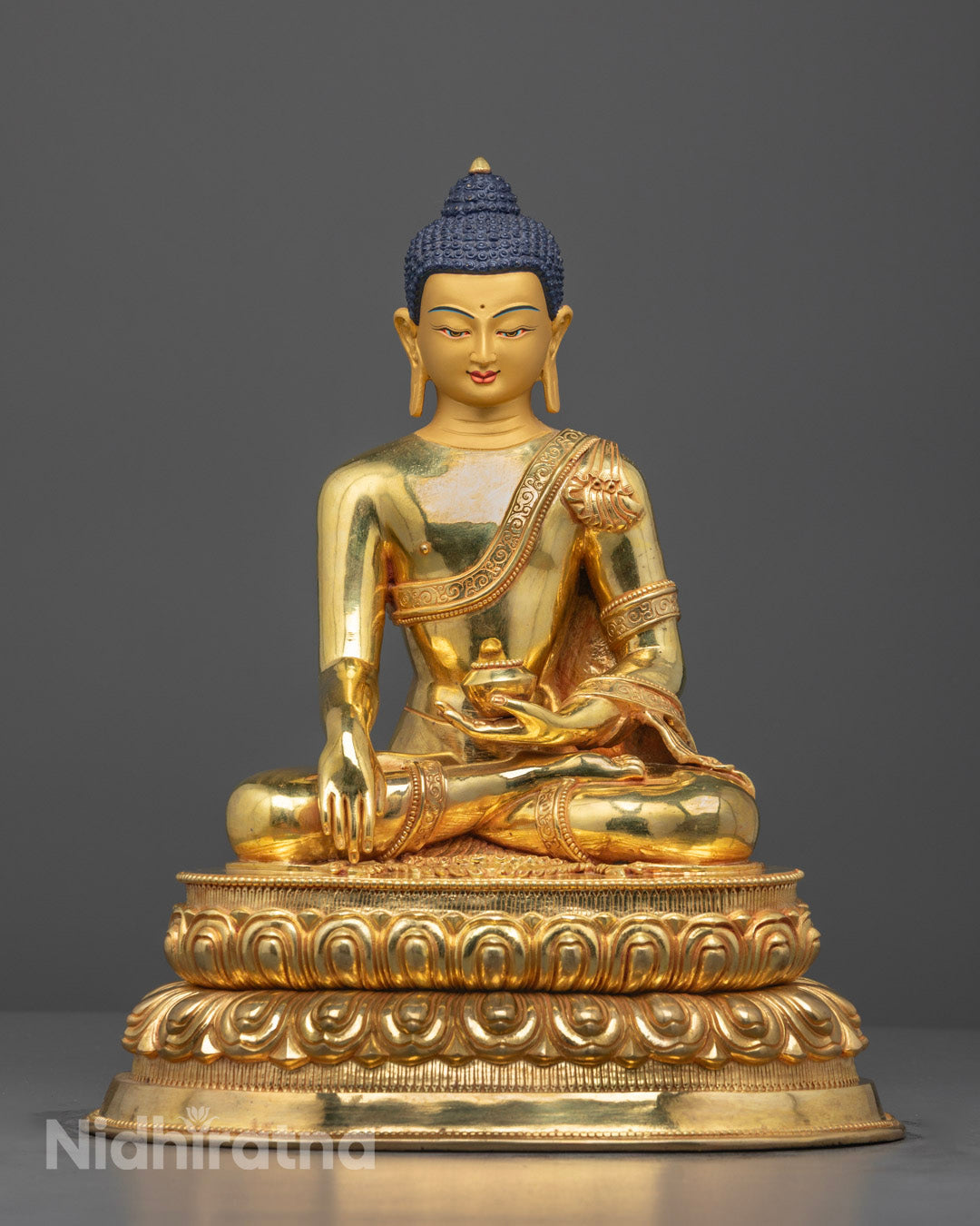 Front view of hand-carved Buddha statue with 24k gold finish on lotus throne.