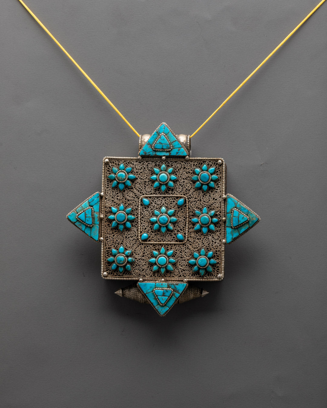 Front view of handcrafted Buddhist copper locket with turquoise gemstone