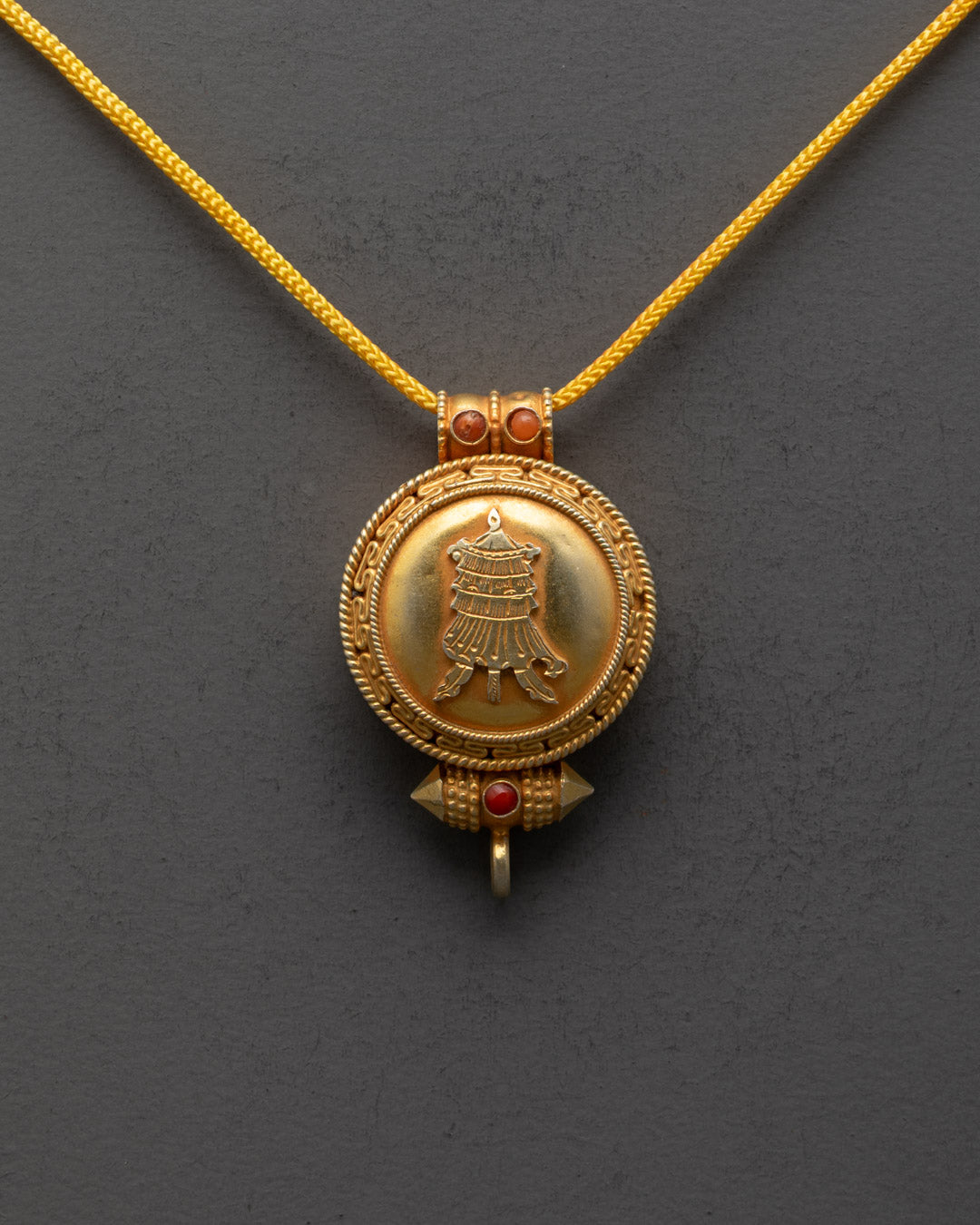 Front view of handcrafted Gyeltshen locket with gold gilding and semi-precious stones