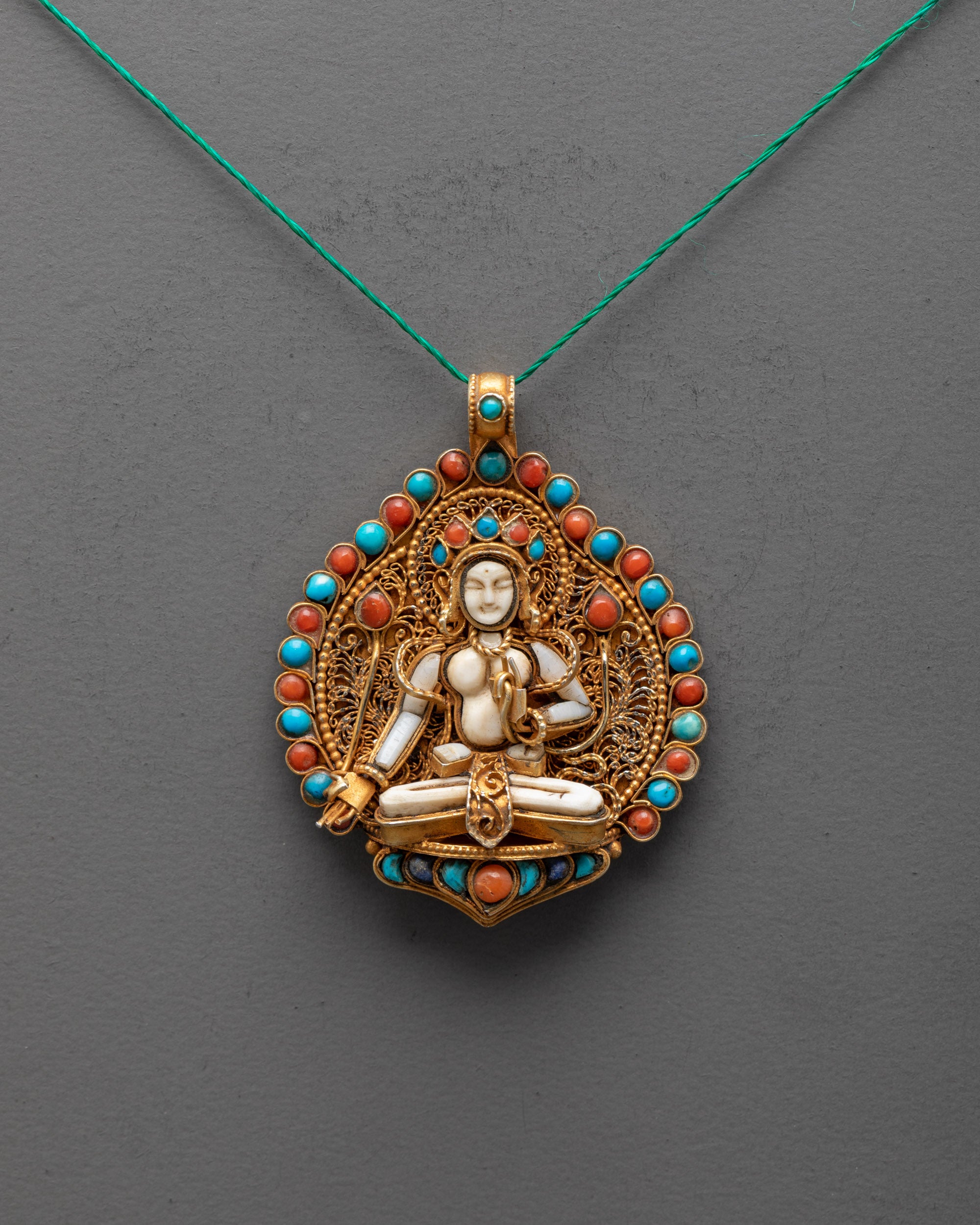 Front view of handcrafted White Tara locket with crystal centerpiece, gold-gilded filigree, and semi-precious stones – spiritual amulet from Nepal.