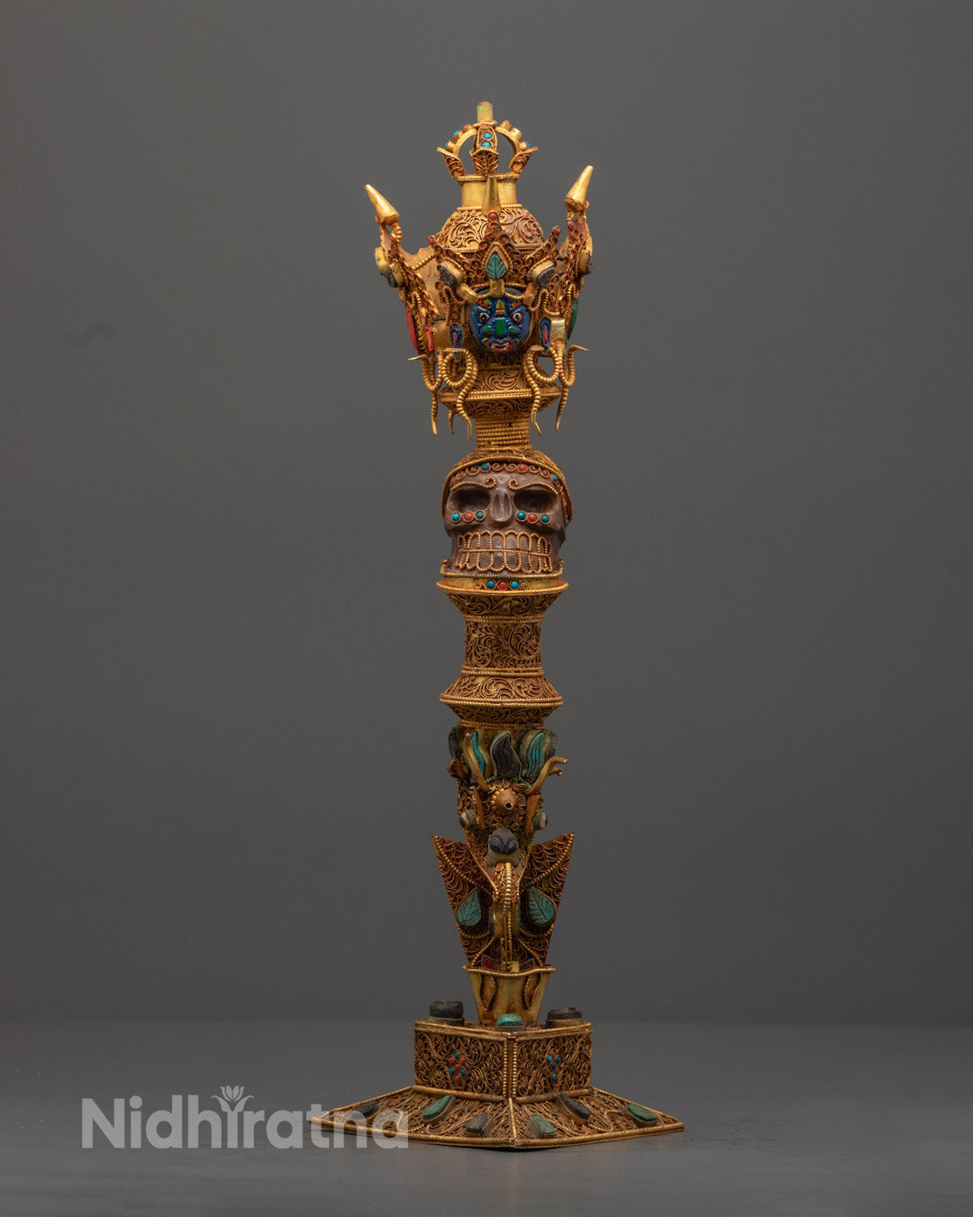 Front view of handcrafted copper Phurba adorned with semi-precious stones and vibrant colors