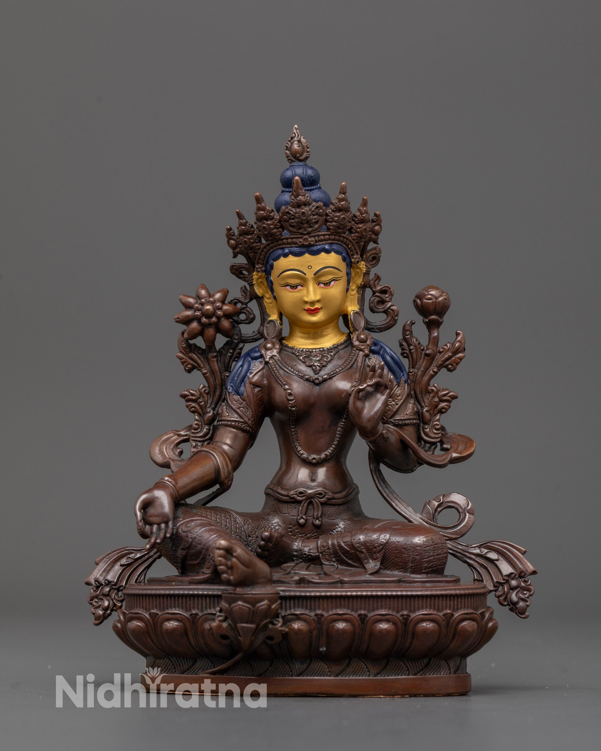 Front view of oxidized Green Tara statue with gold-gilded face in royal ease lotus posture