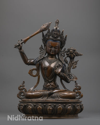 Front view of oxidized Manjushri statue seated on lotus with sword and scripture