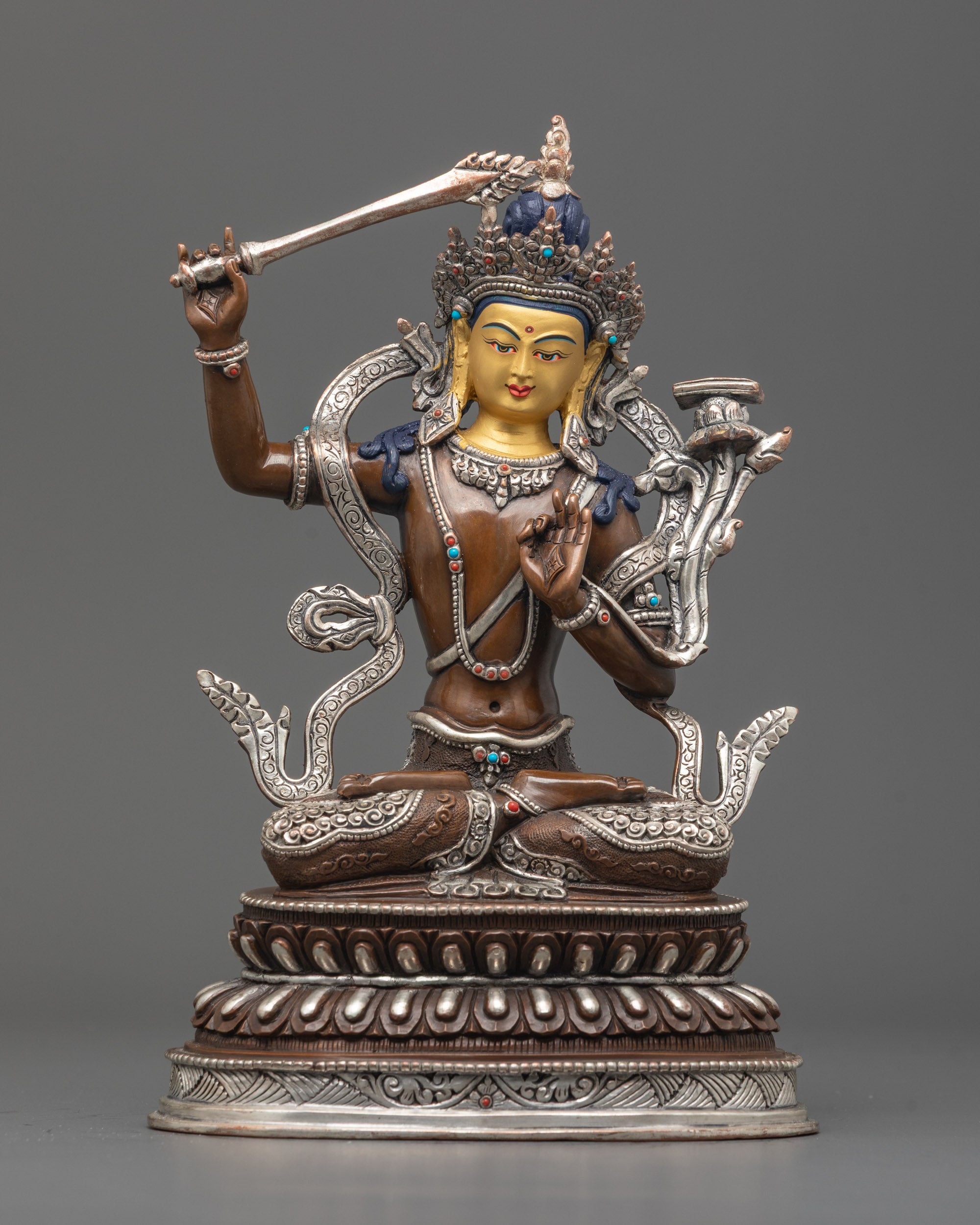 Front view of oxidized Manjushri statue with 24K gold face and silver-plated details