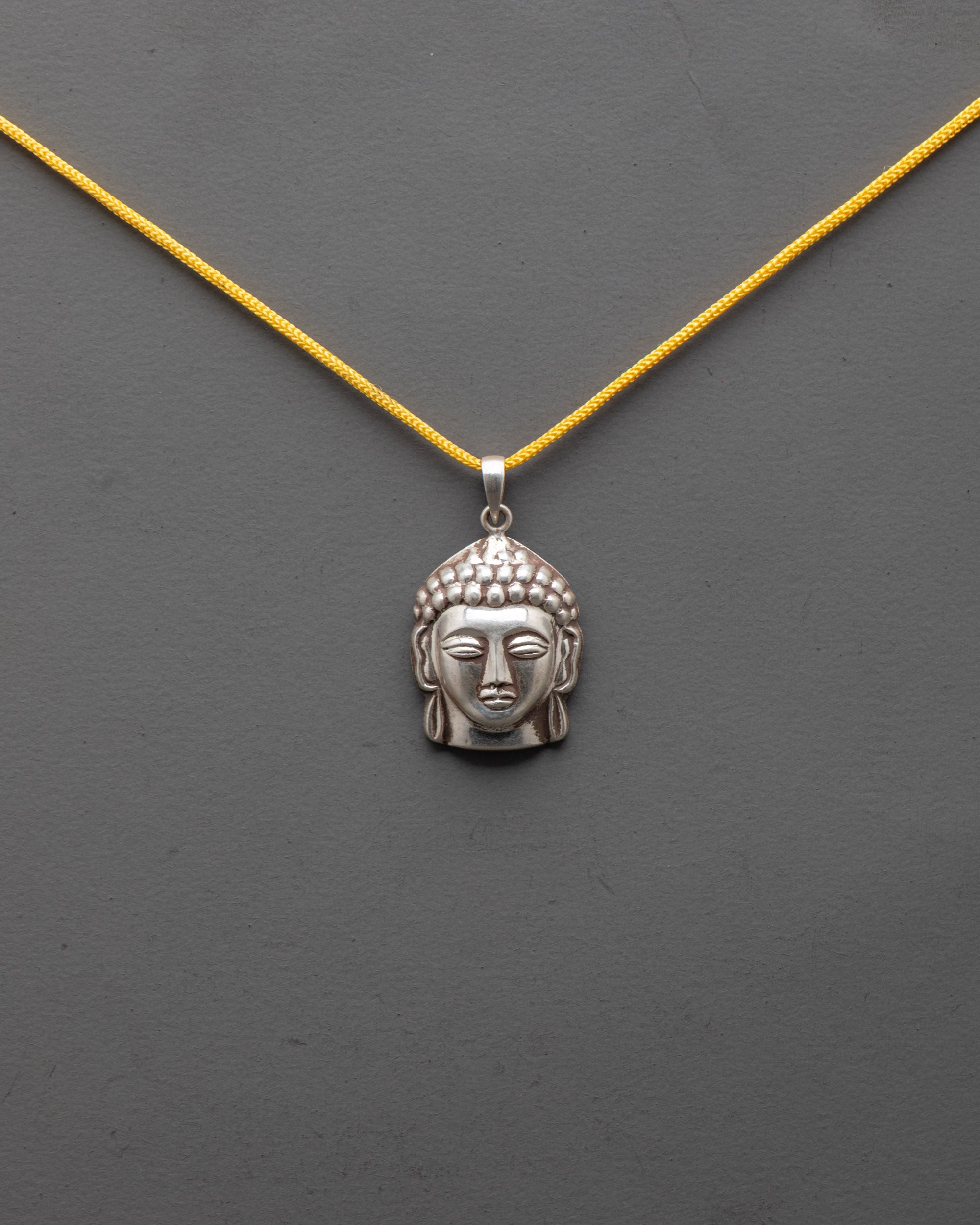 Front view of pure silver Buddha Head Locket showing serene carved spiritual symbol