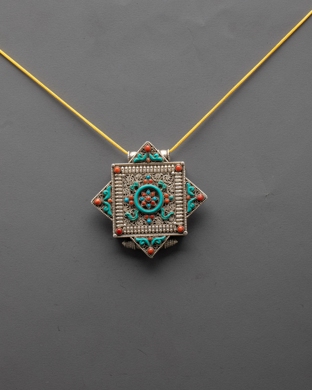 Front view of silver-plated Mandala Locket with turquoise and coral stones