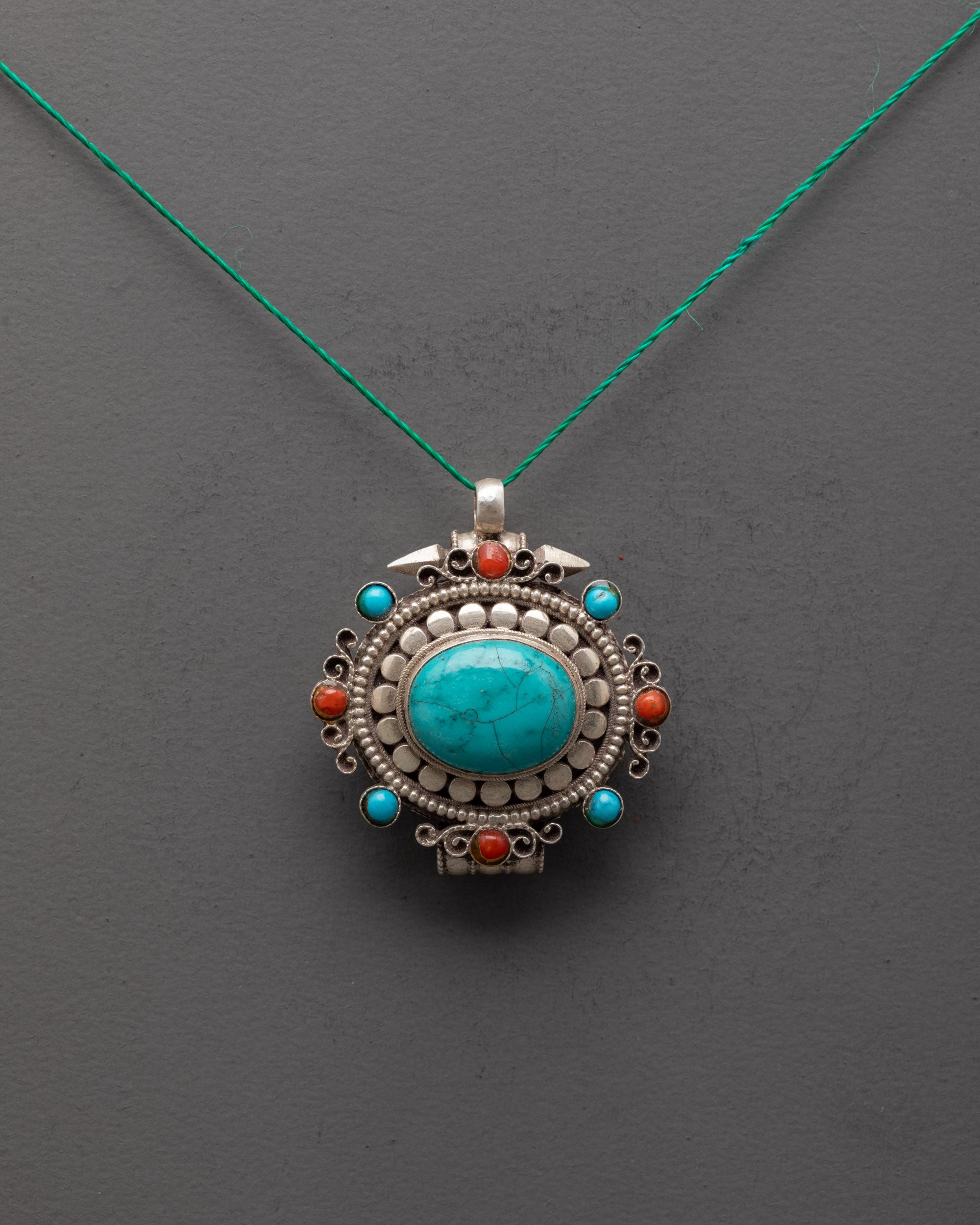 Front view of silver turquoise locket with coral stones, handcrafted by Himalayan artisans in Nepal