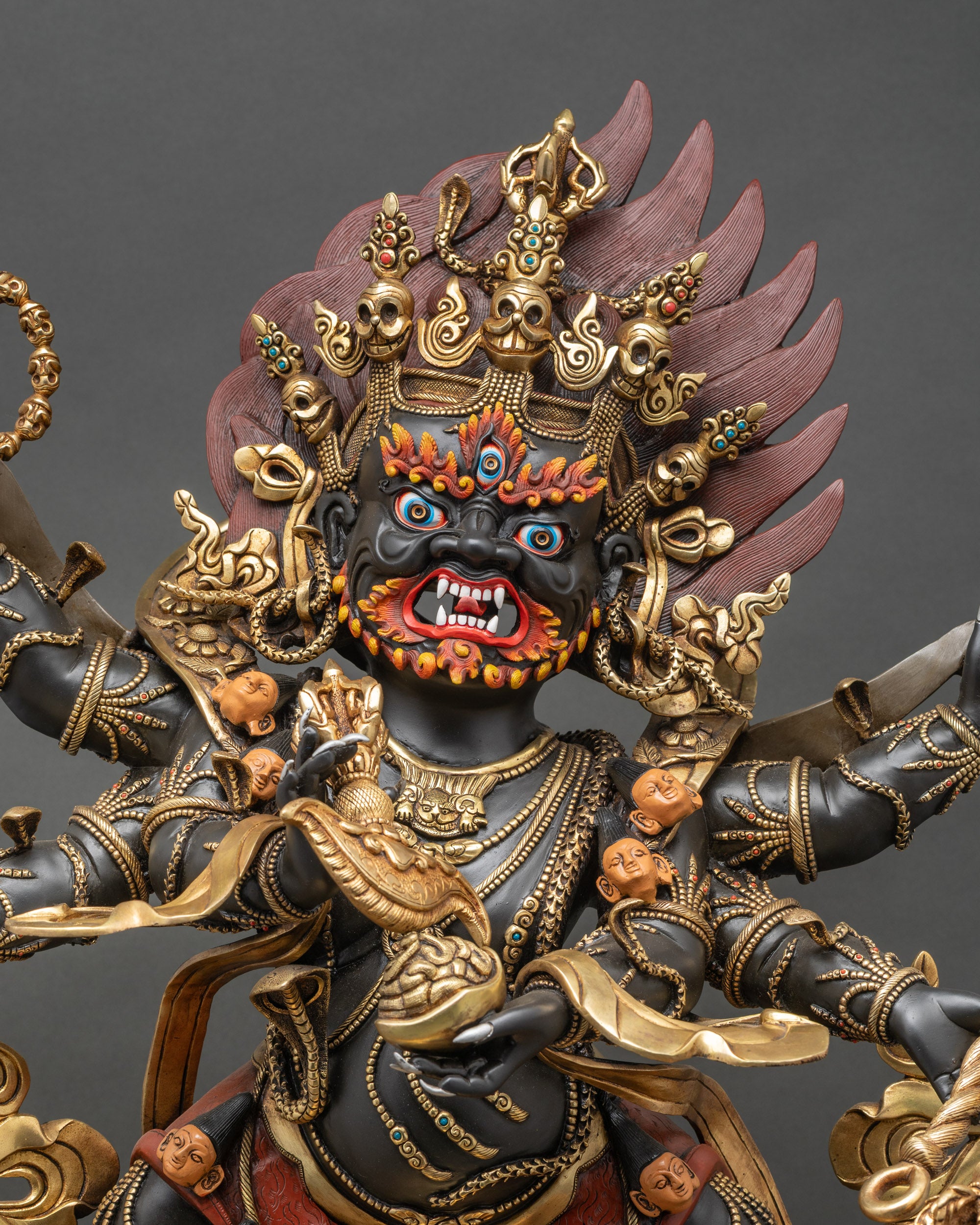 Front view of six-armed Mahakala sculpture on lotus throne with blazing halo
